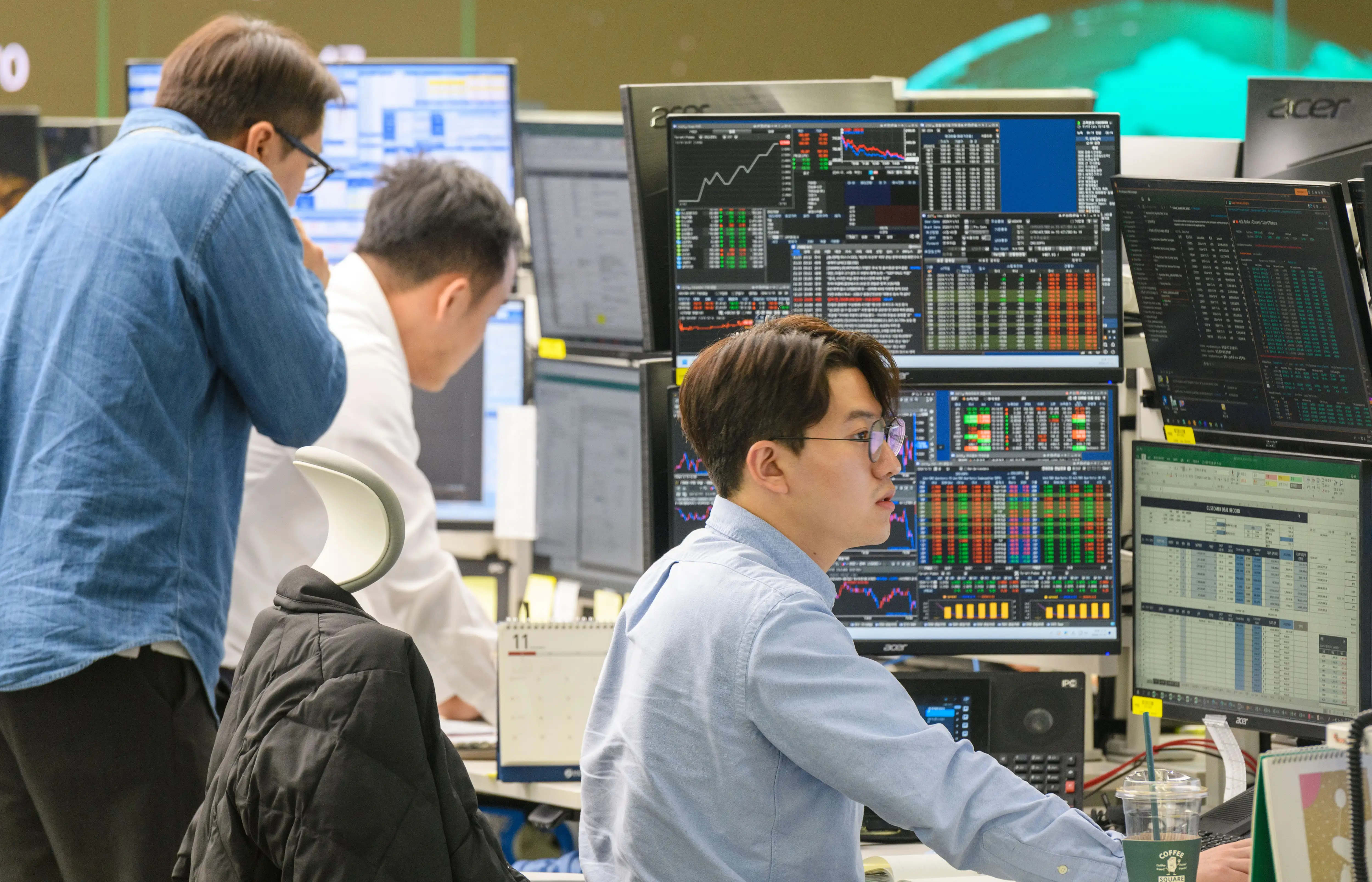 Currency traders watch monitors at the foreign exchange dealing room