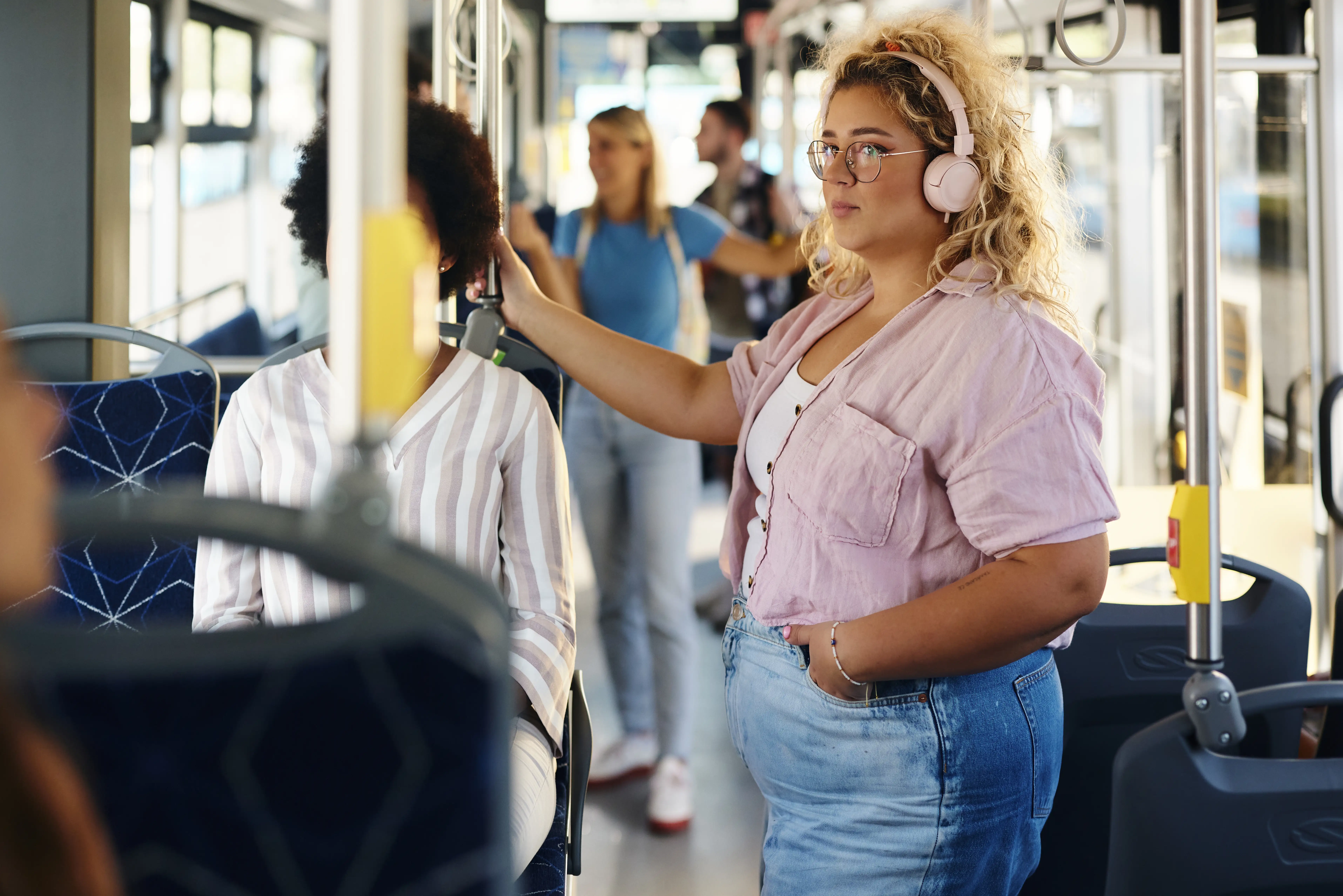 A woman listens to a podcast on a crowded train