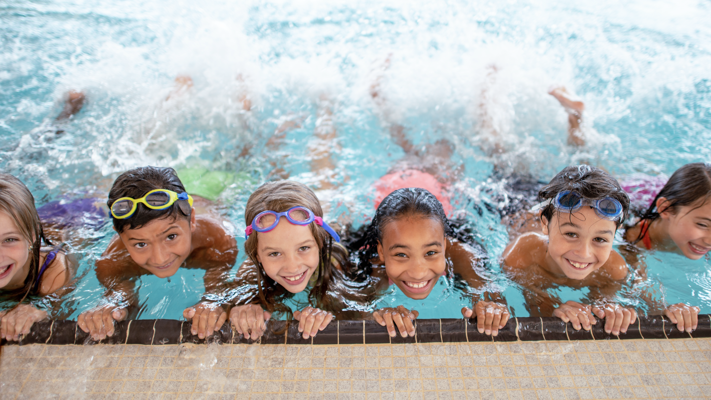 Kids at side of pool in swimming lesson