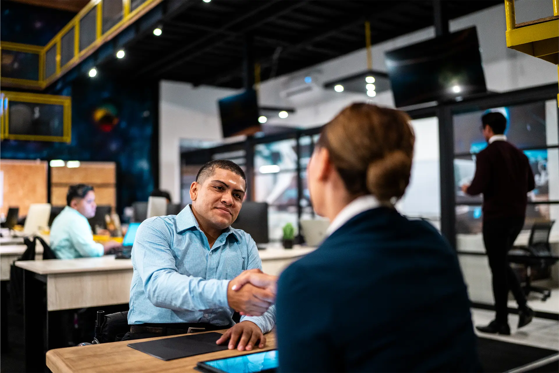 A man and woman shaking hands in an office