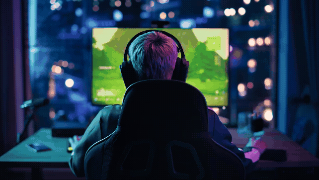A female gamer with her back to the camera playing on a computer