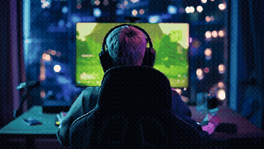 A female gamer with her back to the camera playing on a computer
