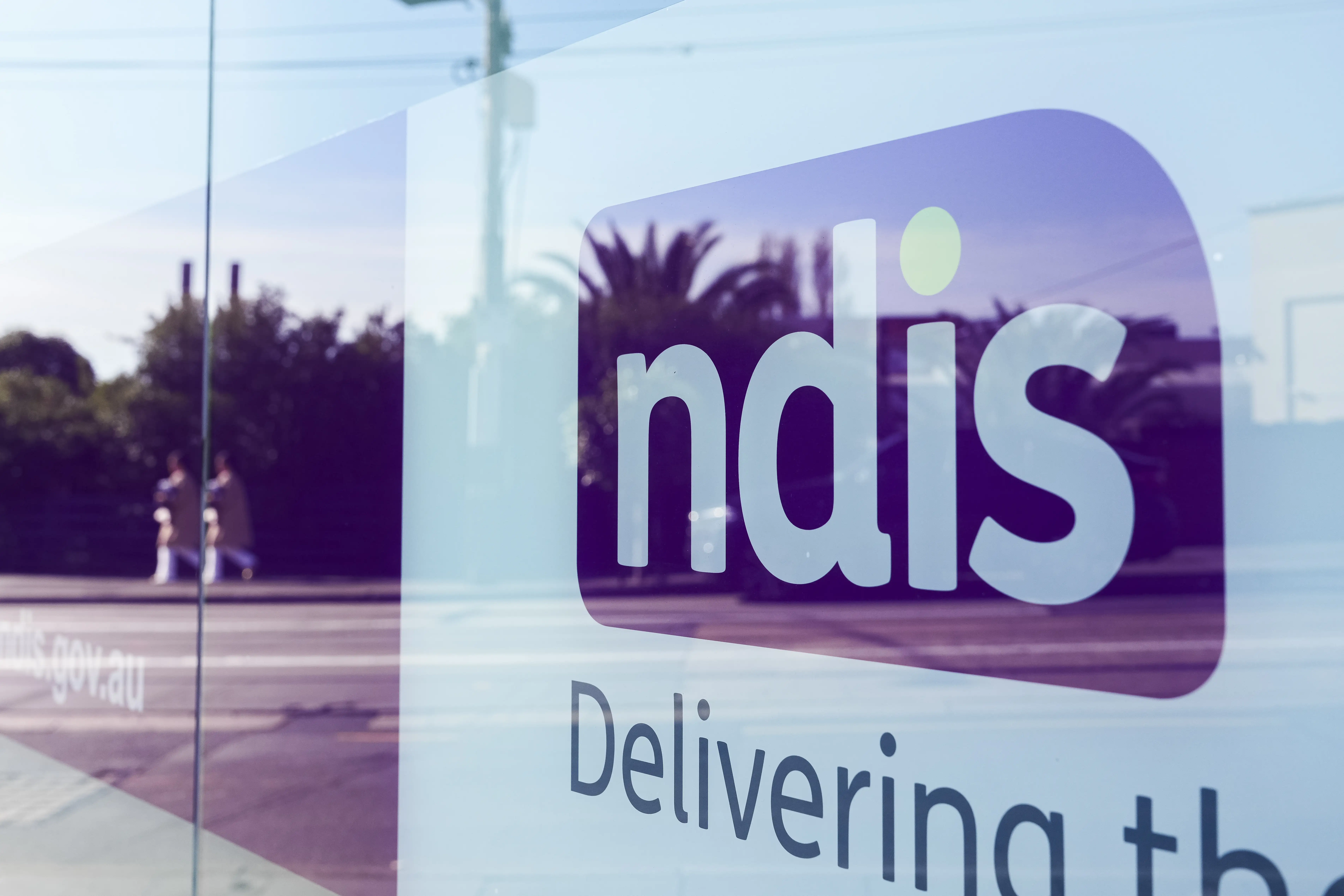 The purple and white NDIS signage outside an office in Melbourne