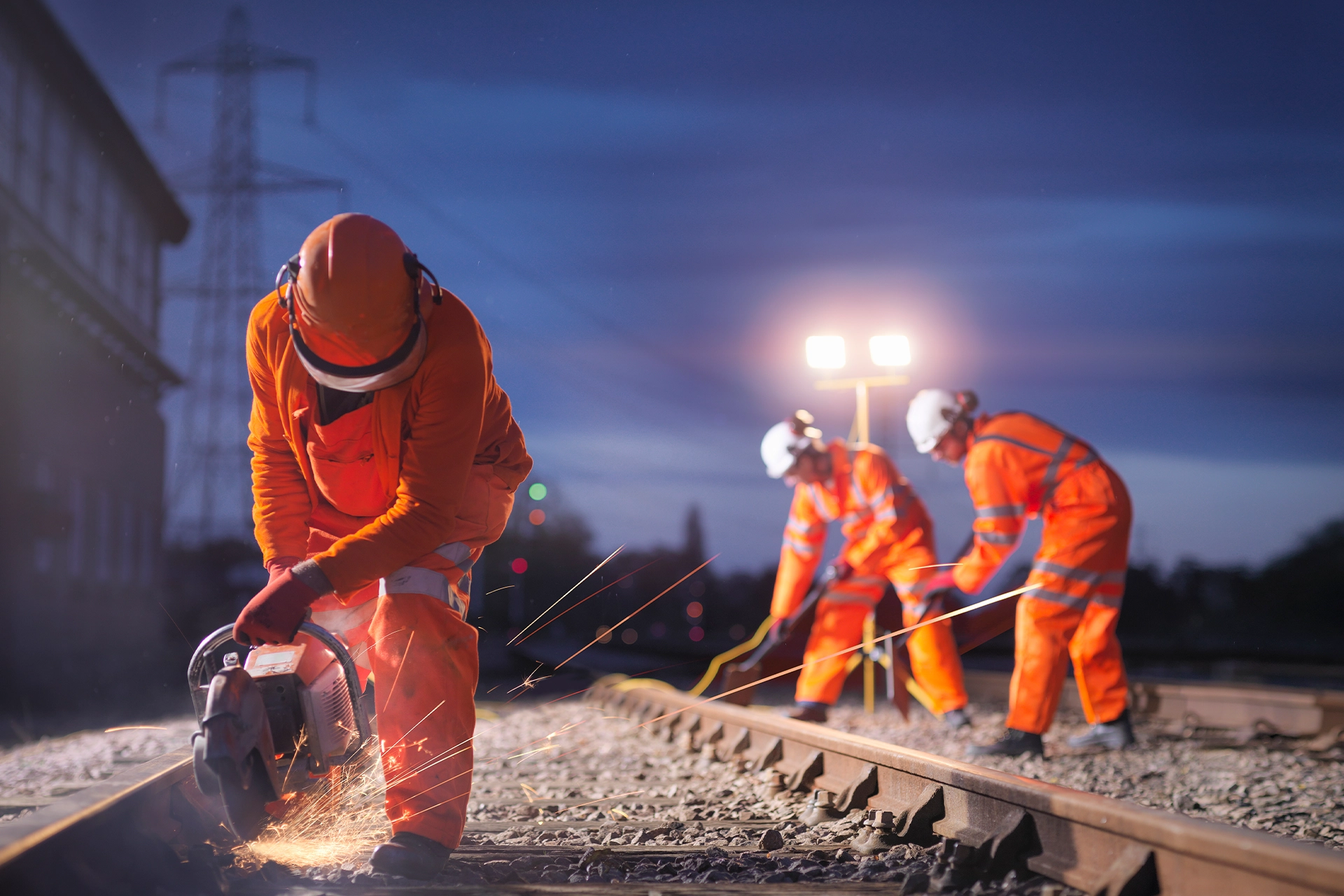 Workers grinding train tracks at night