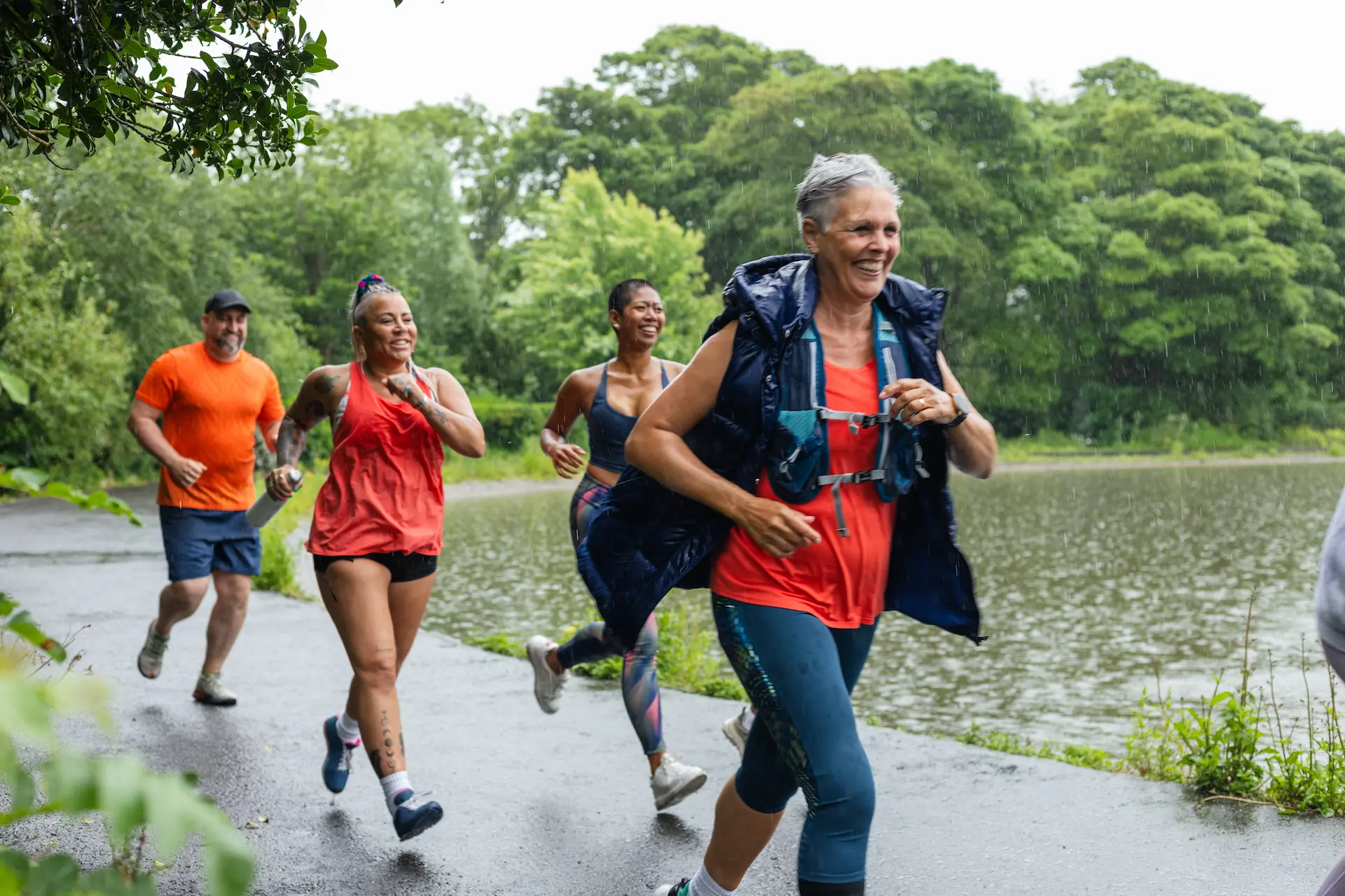 Smiling group of people jogging beside a lake