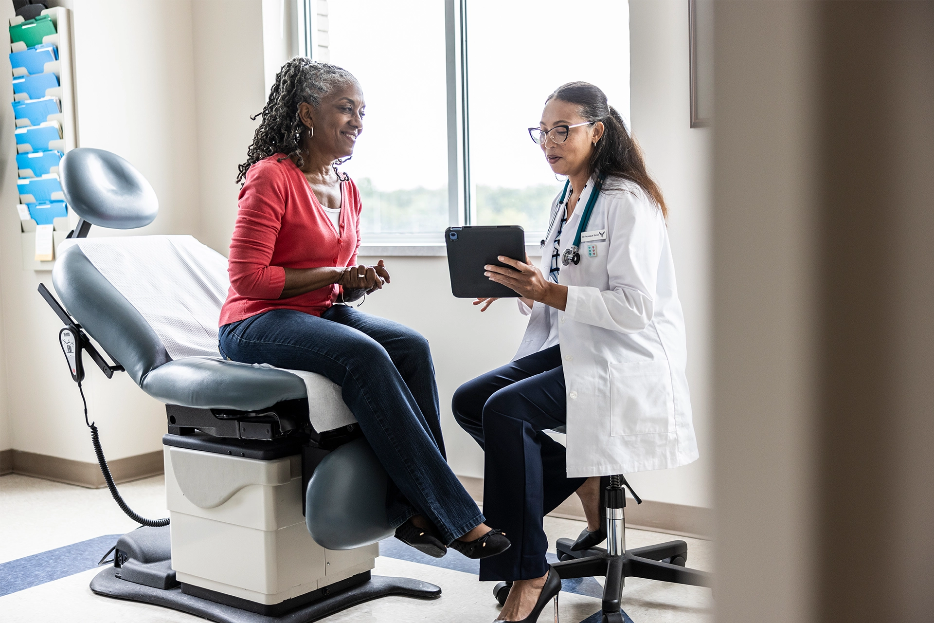 Female doctor and patient looking at a tablet device in doctor's surgery