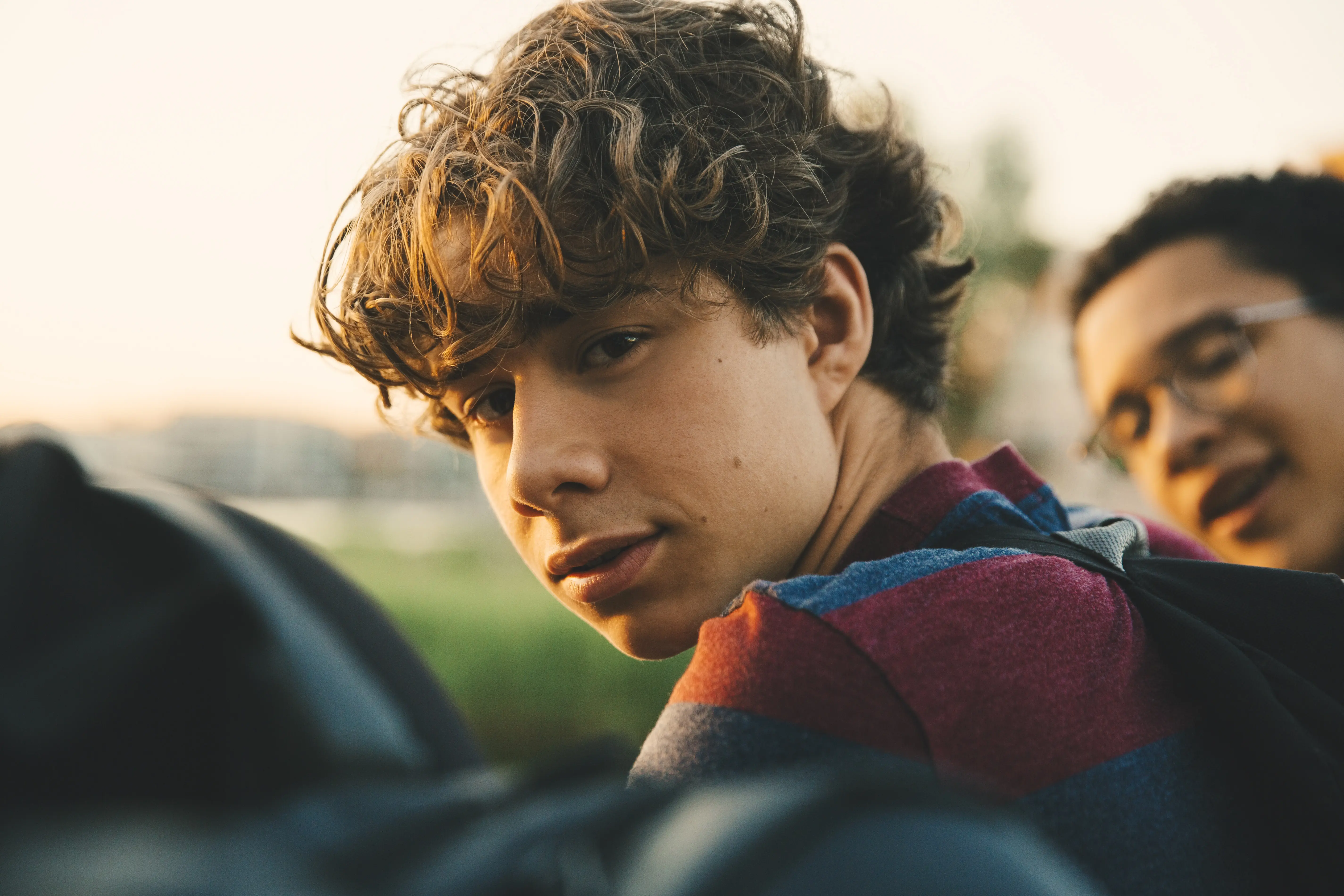 Portrait of male teenager with friends standing in city