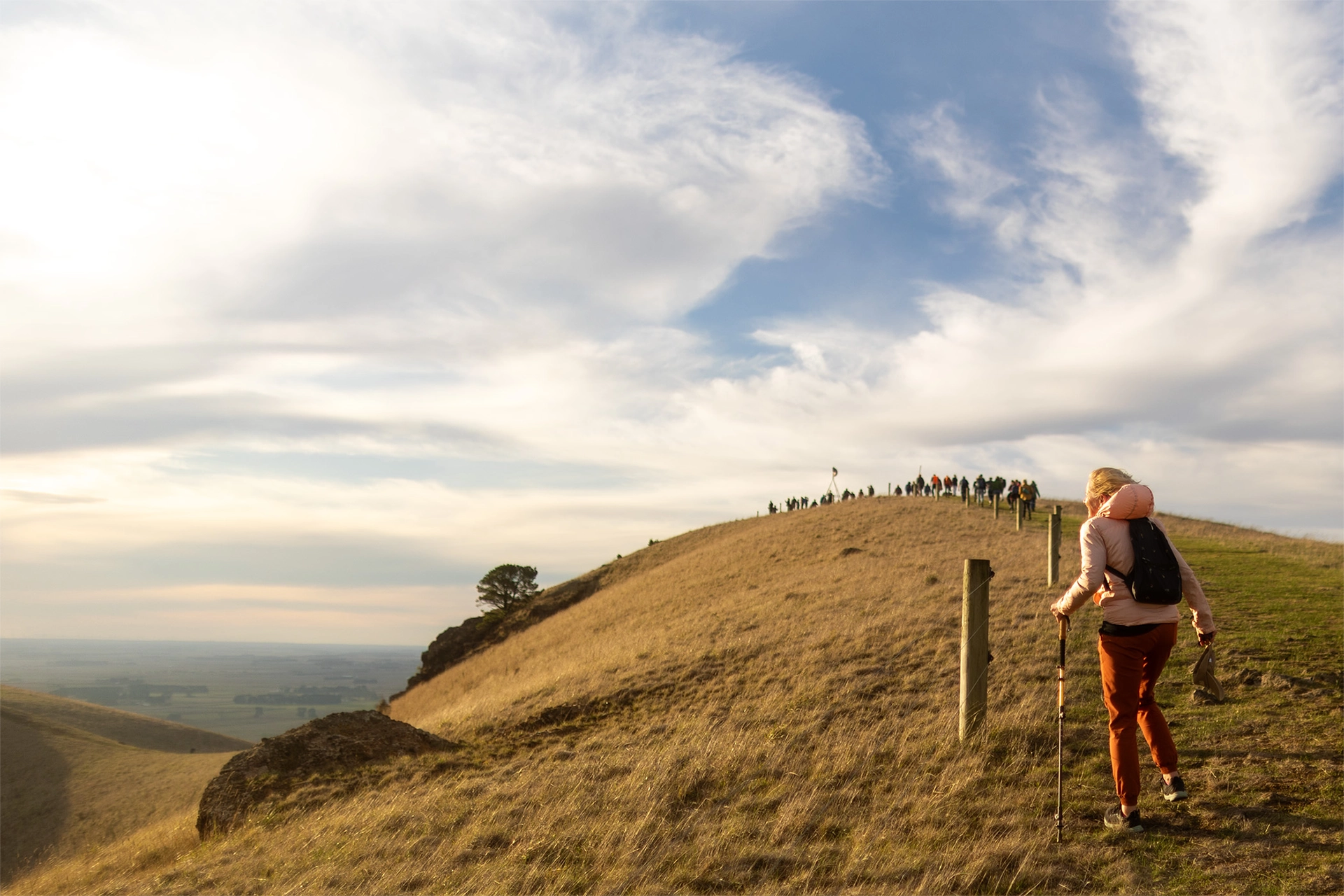 People walking up a grassy hill