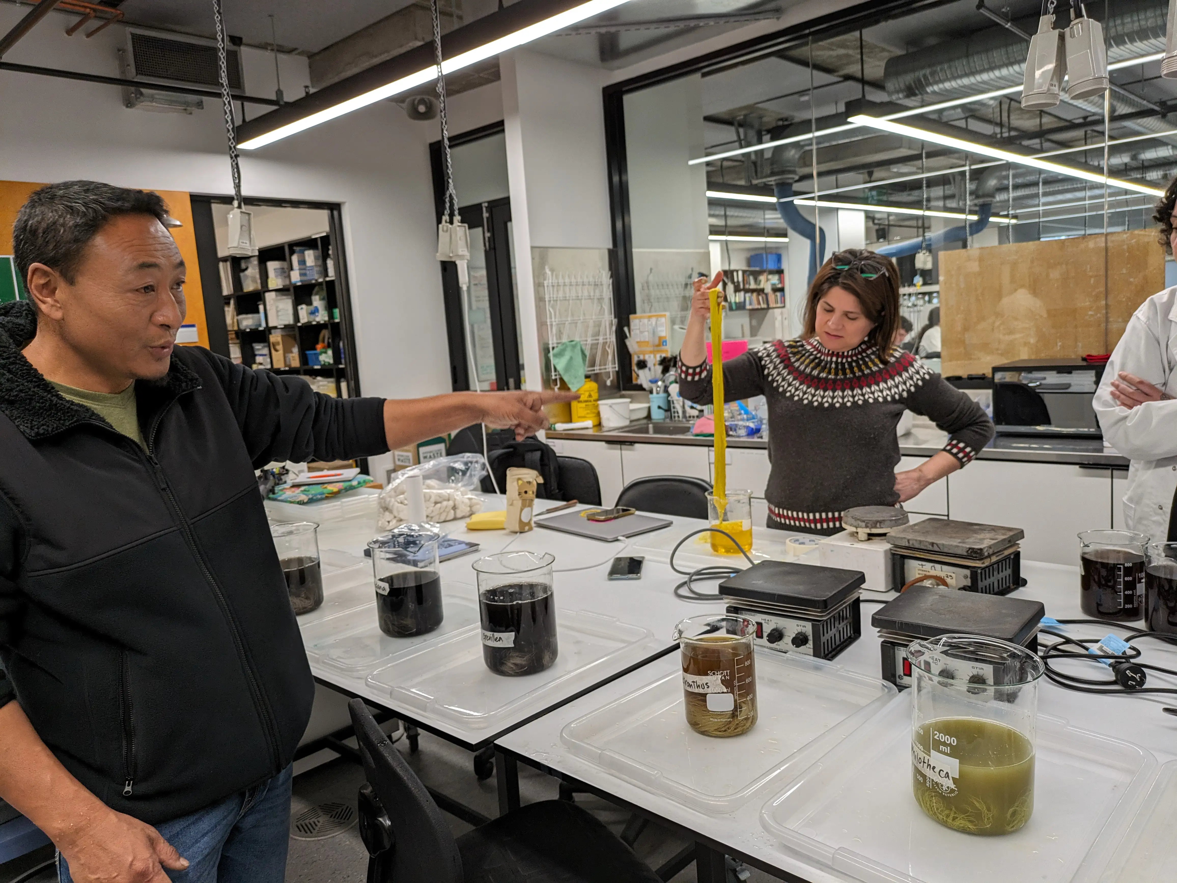 Kencho with students in lab dyeing yarn a bright yellow