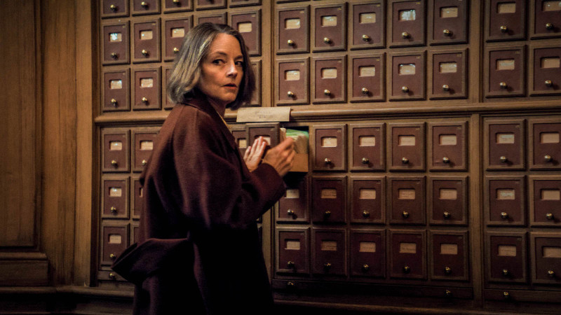 A mature woman looking through card filing drawers