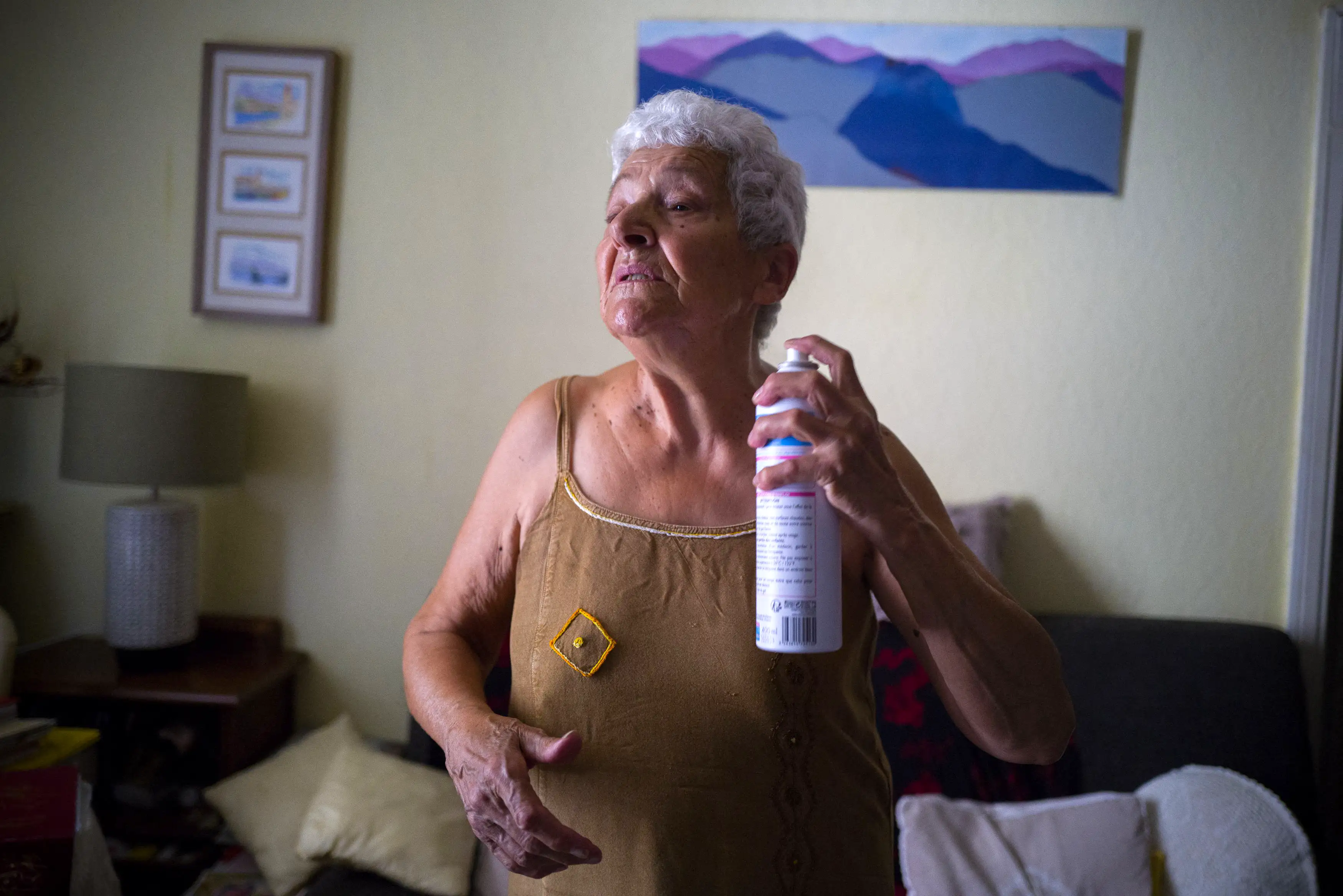 Jackye Lafon, an 81-year-old, refreshes herself with a water spray in her flat in Toulouse during a heatwave in 2022