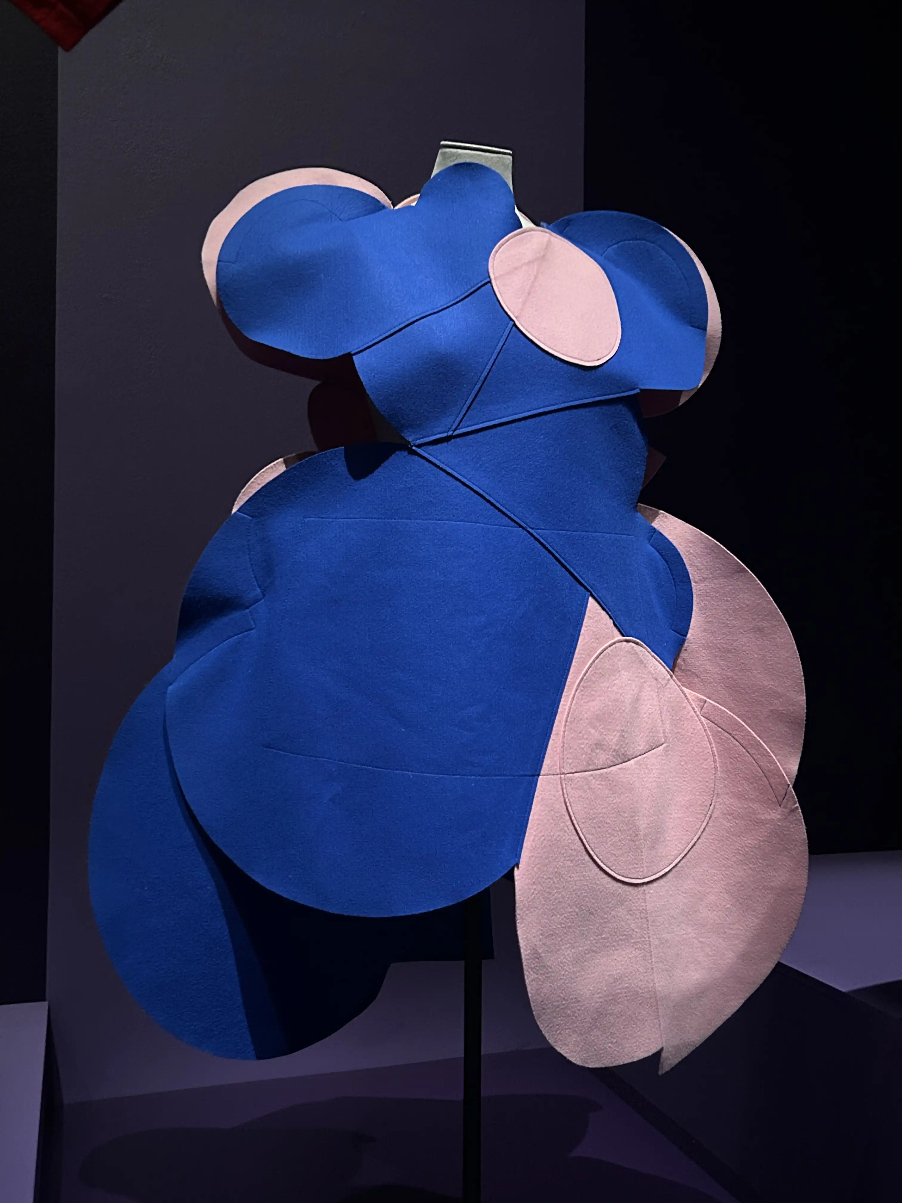 Kawakubo dress in blue and pink with a large bodice creating a broad geometry, on display in the National Gallery of Victoria