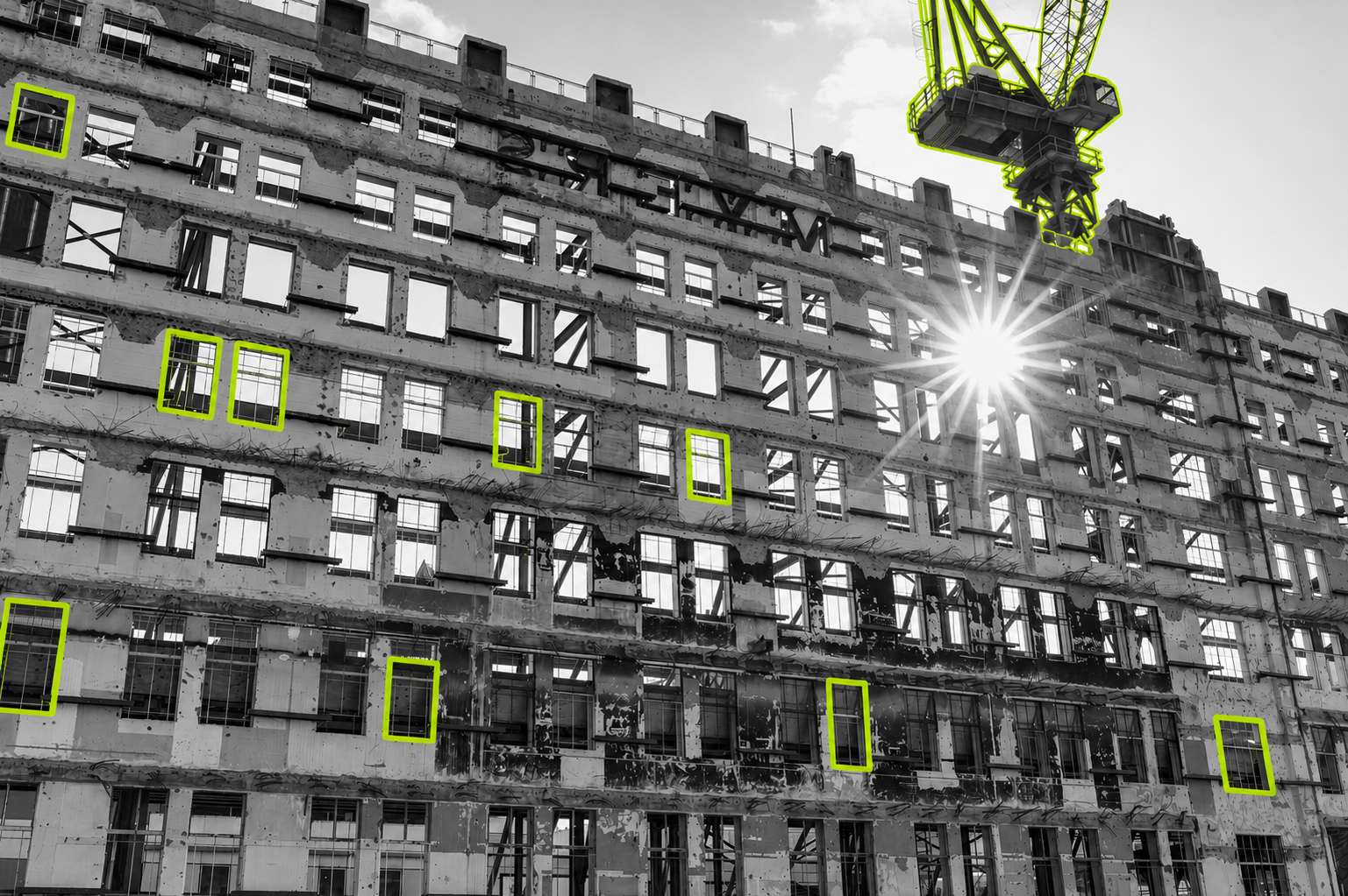 A black-and-white photo of a building site with elements picked out in lime green