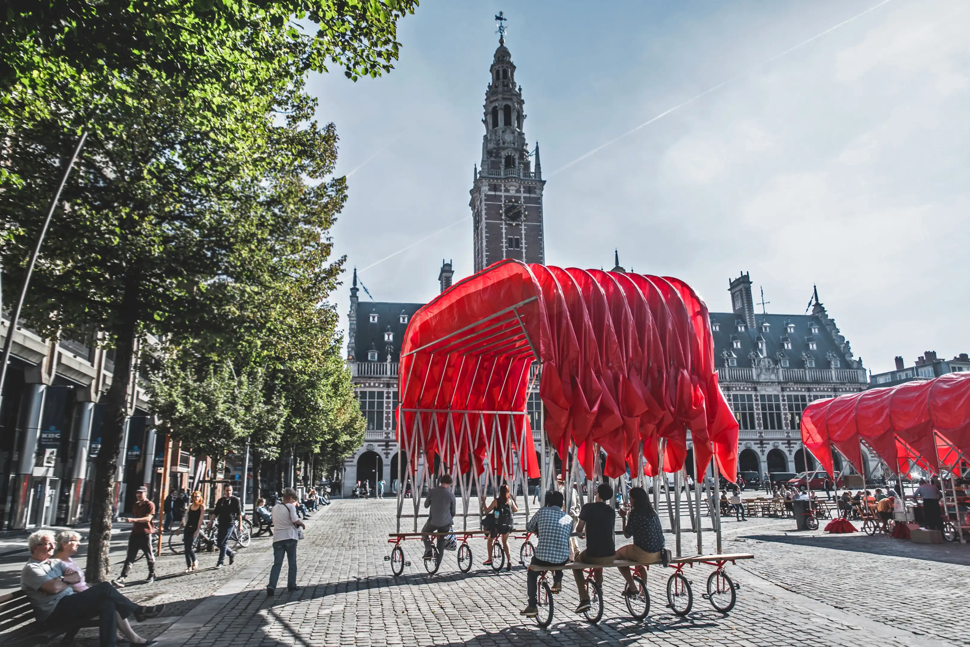 A movable canopy is pedalled through an open civic square