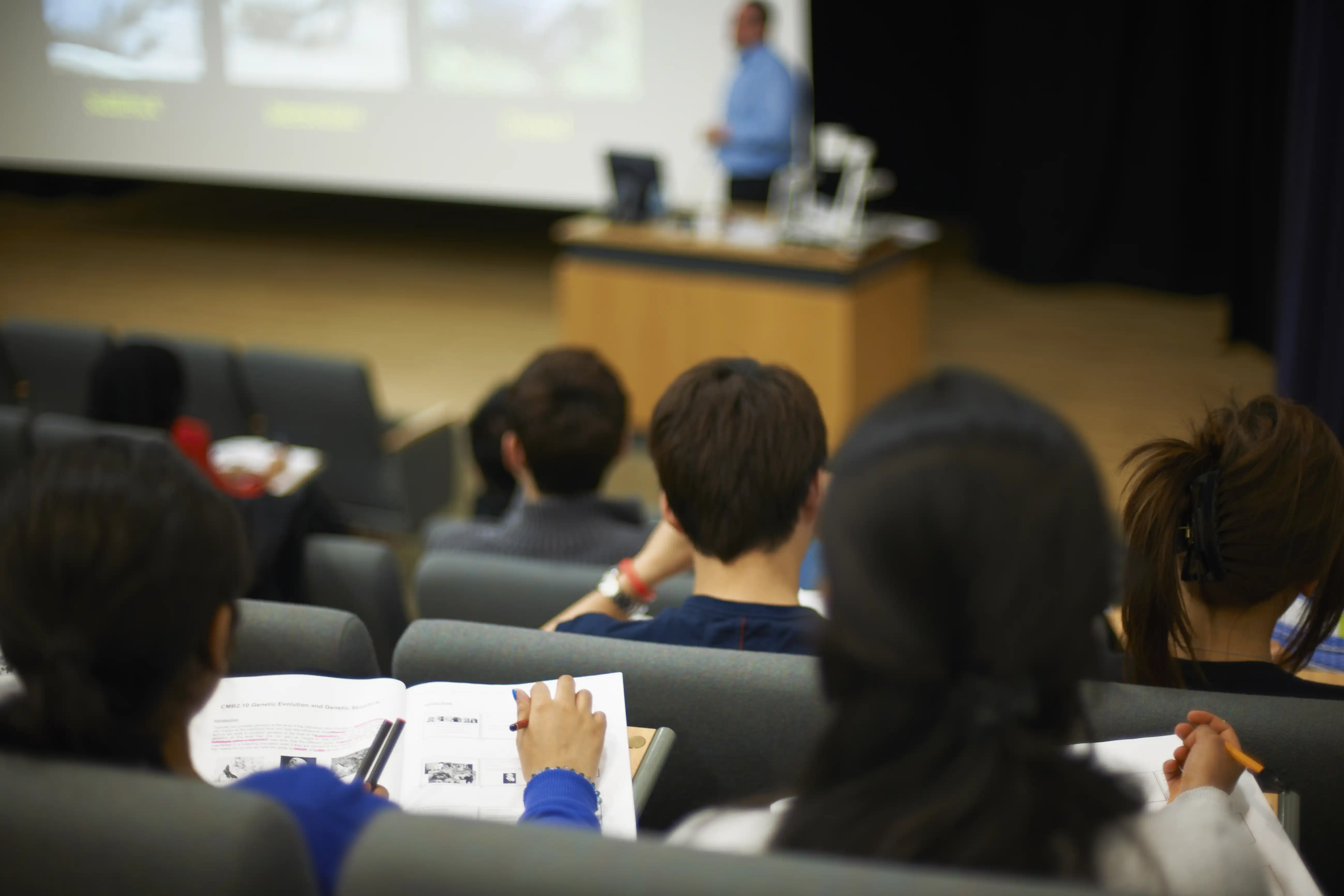 Students in a lecture hall taking notes