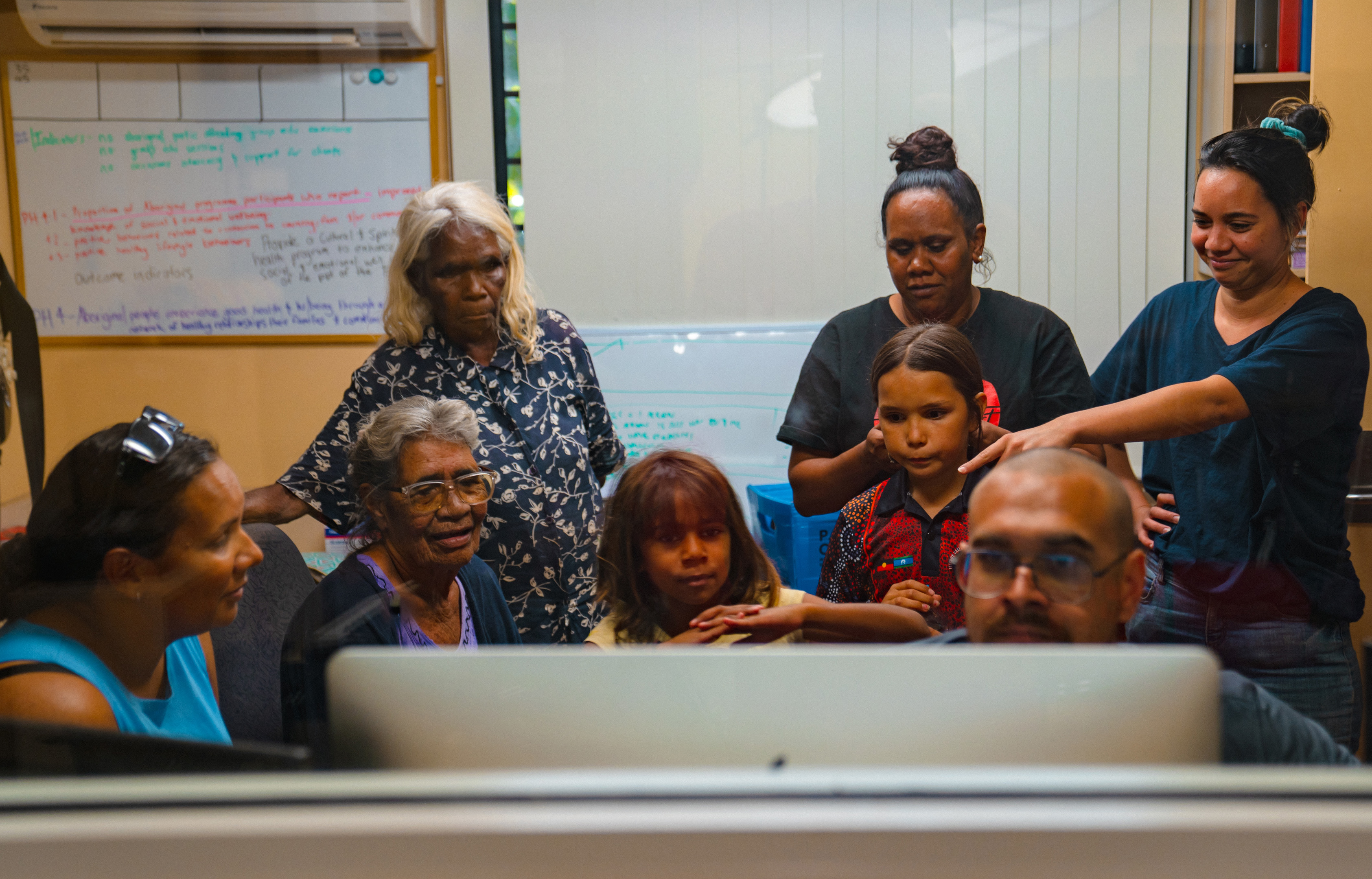 A group of Indigenous collaborators at a computer