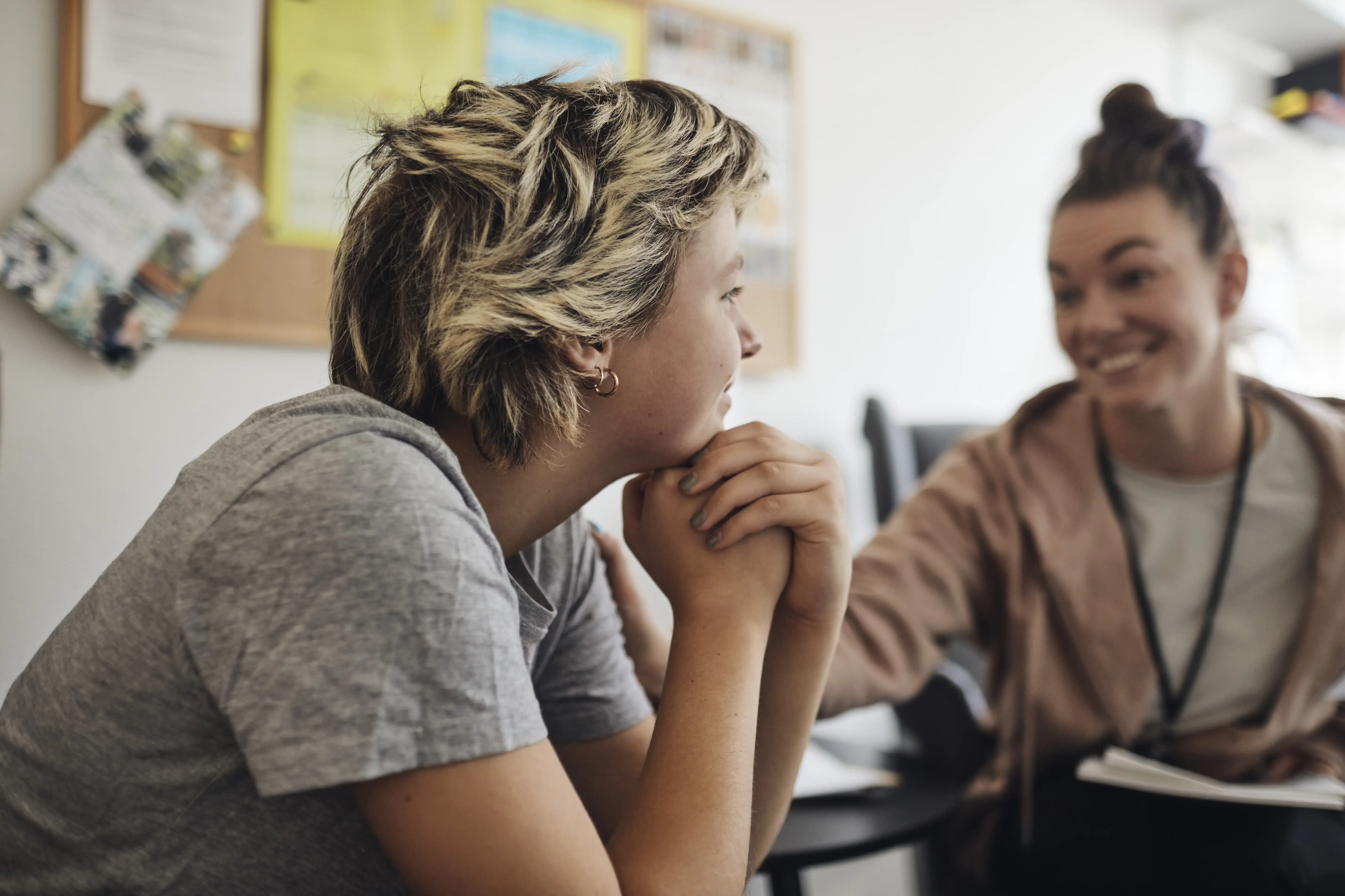 Smiling mental health professional looking at female student