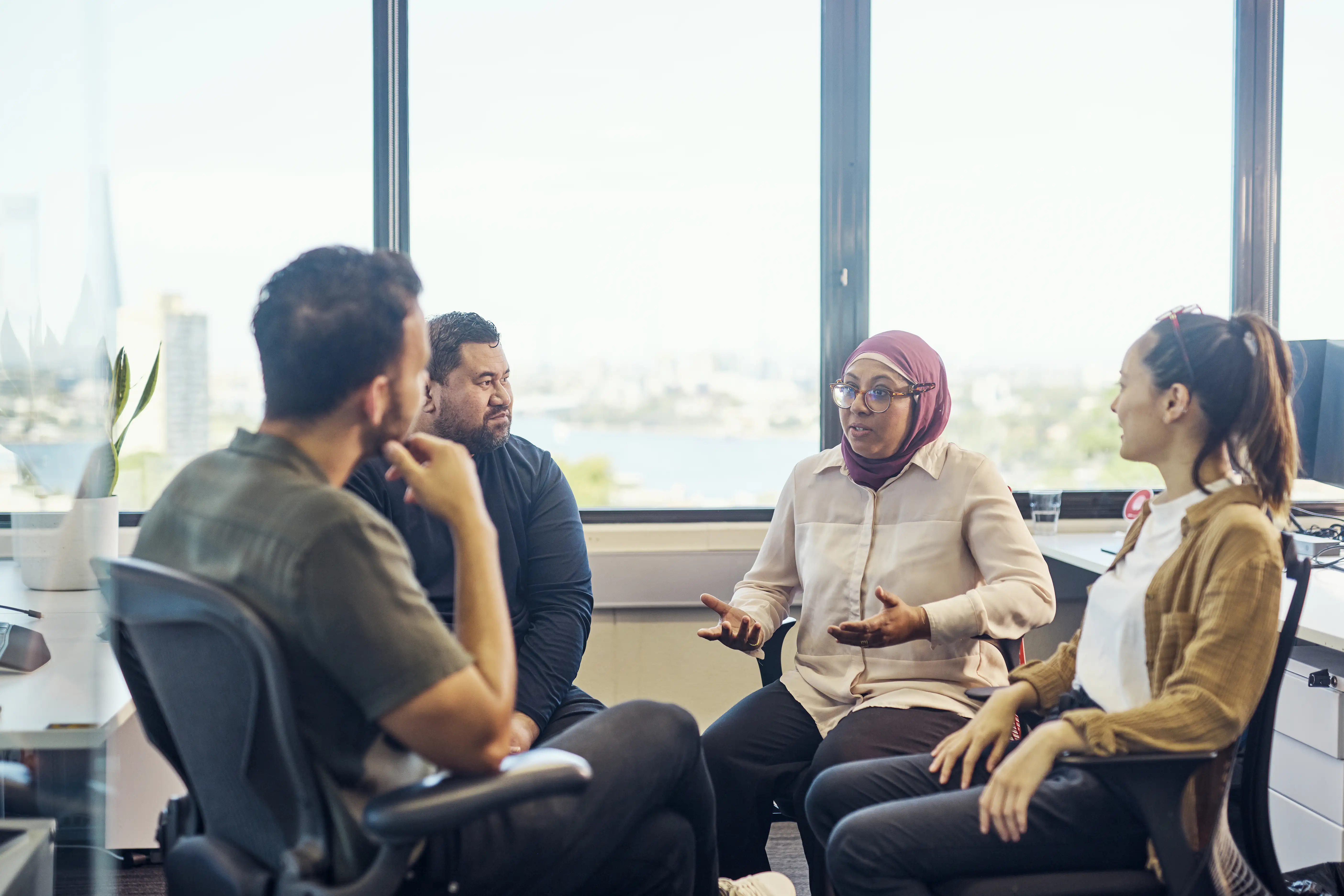 Indonesian-Australian woman talking with participants in a group therapy session