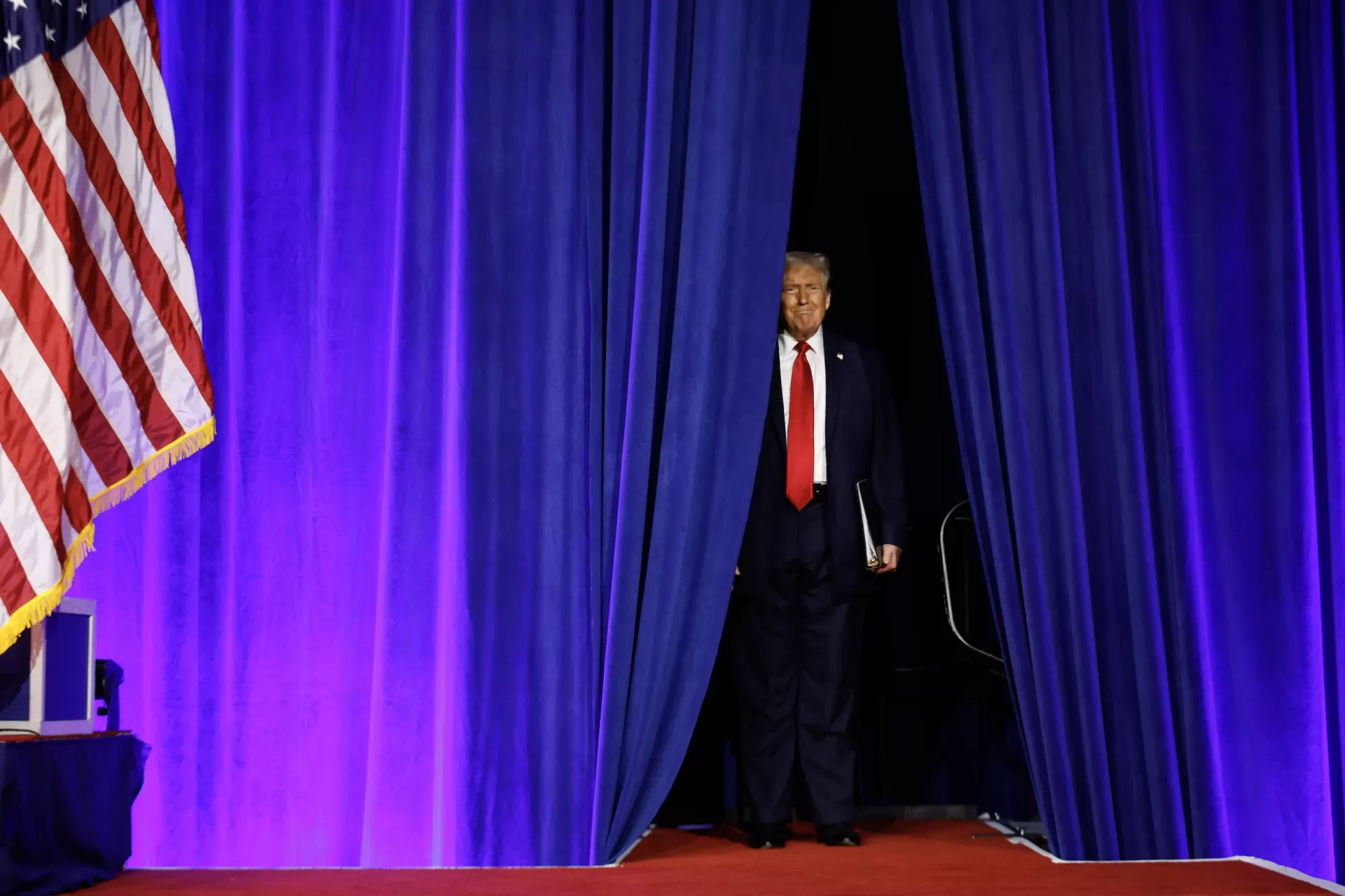 Donald Trump emerges from behind curtains