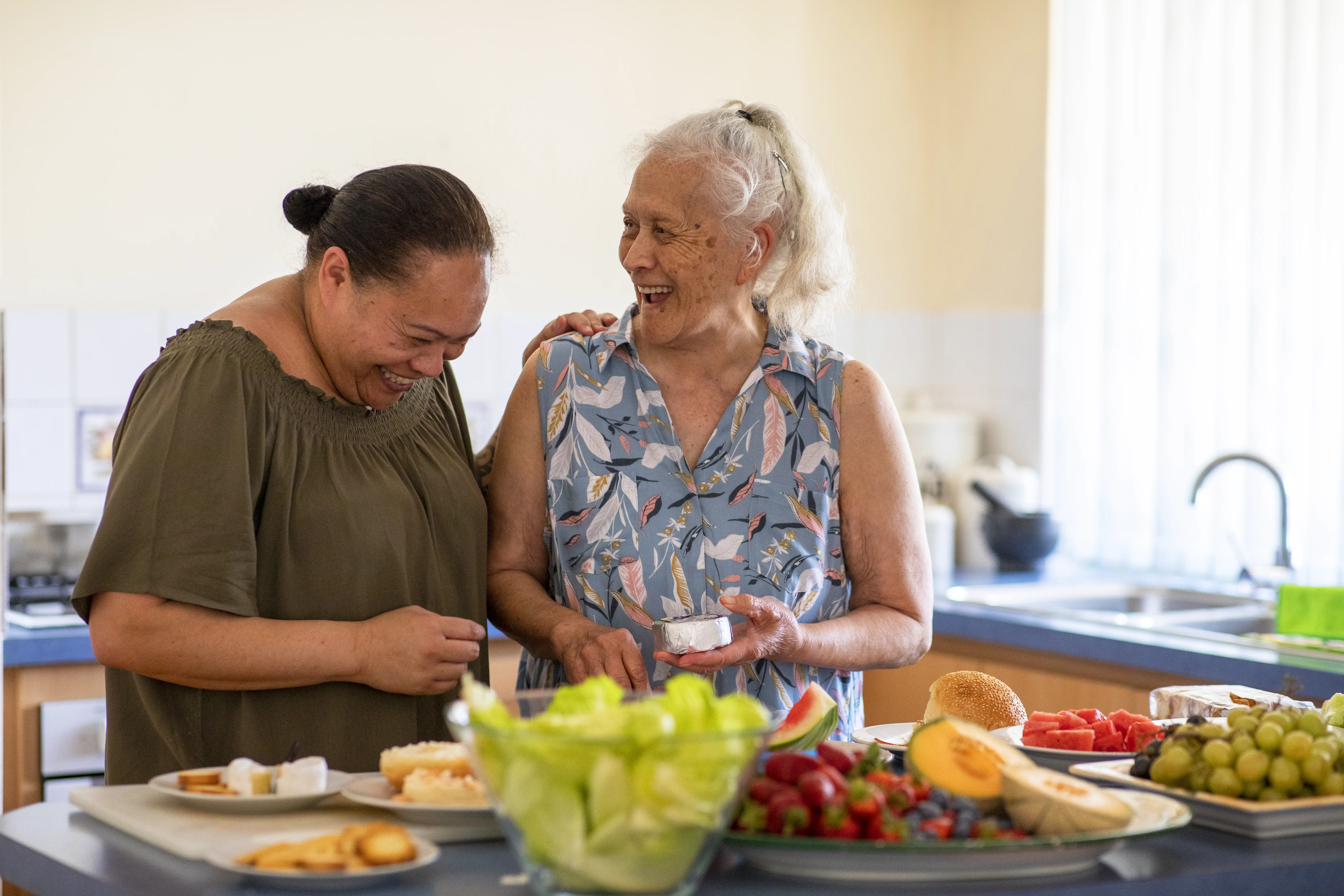 Senior Pacific Islander woman and her mature daughter preparing food together in their kitchen at home.