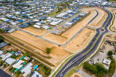 Aerial view of Smithfield Cairns construction site revealing new road development and adjacent residential areas