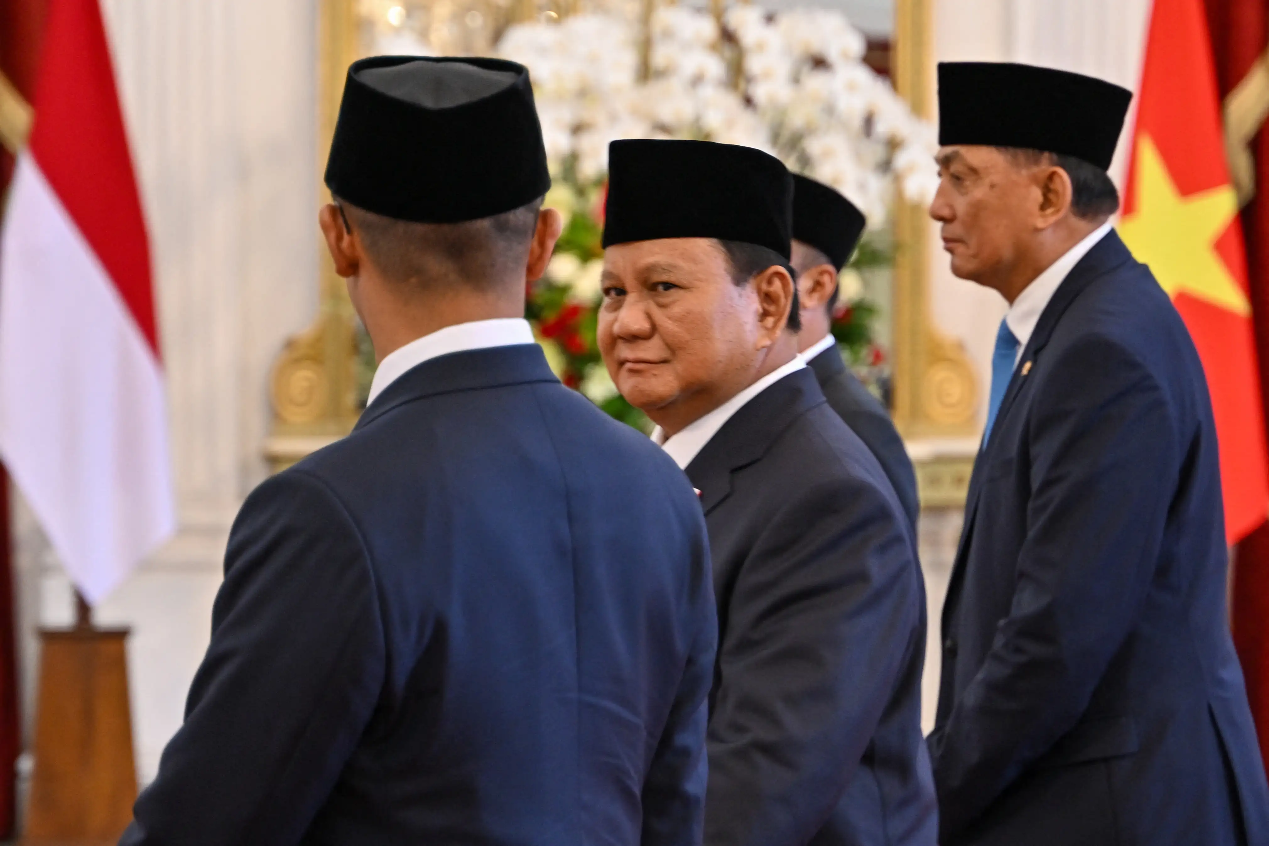 Indonesia's President Prabowo Subianto walks with his new cabinet ministers at the presidential palace in Jakarta