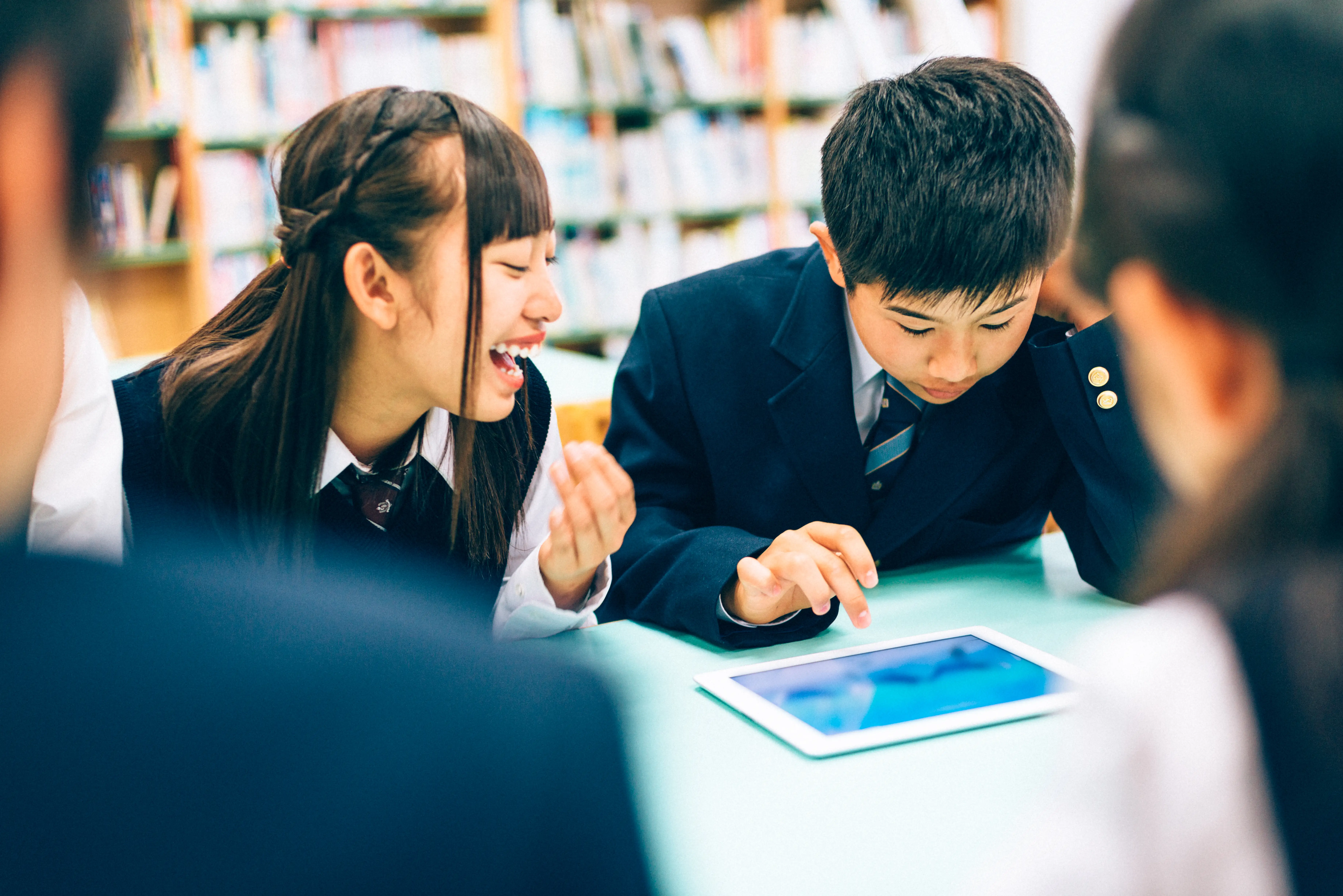 School students playing a fun digital tablet game.