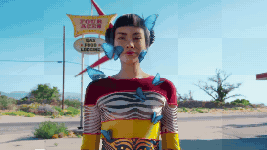 A GIF of Lil Miquela surrounded by blue butterflies
