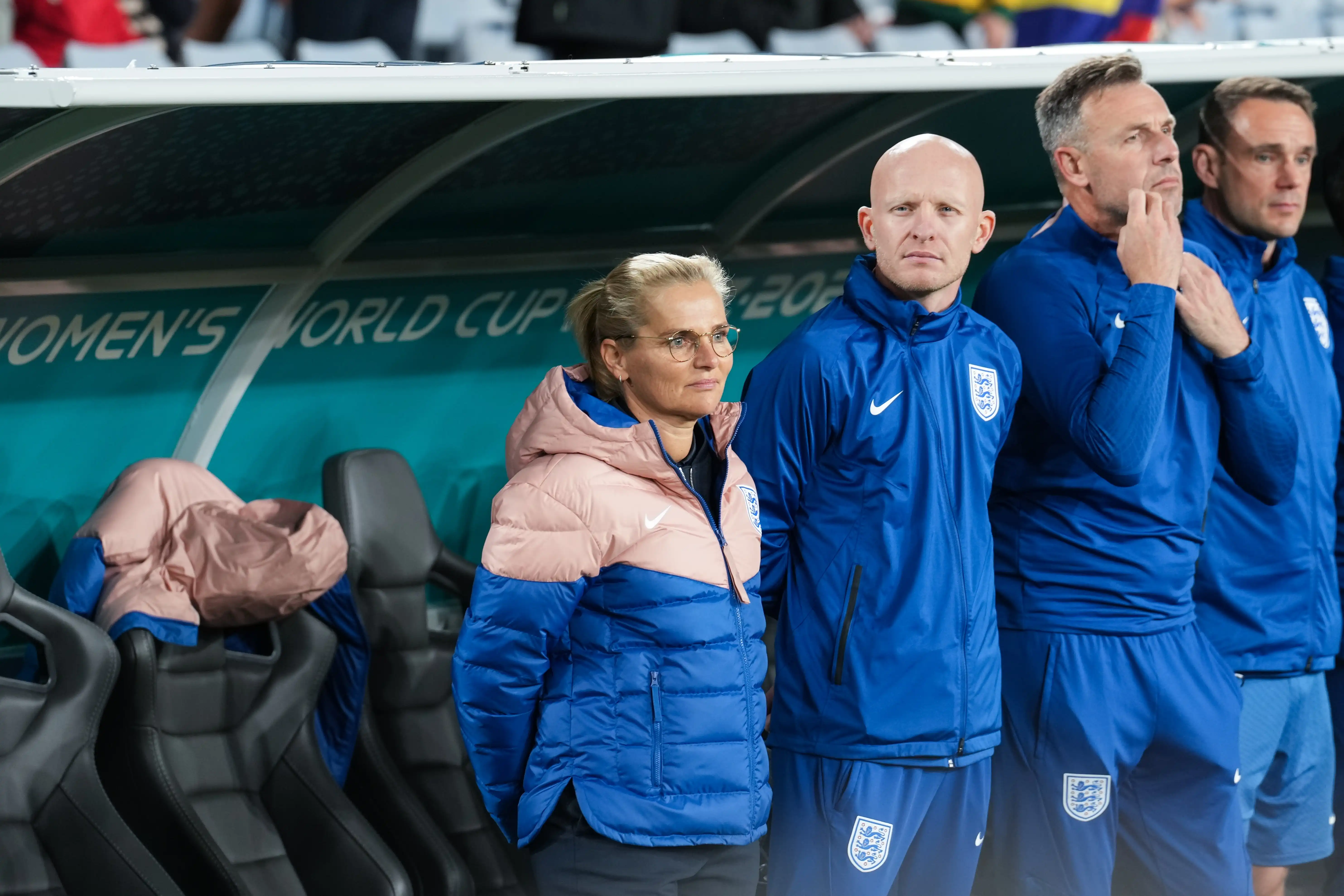 Female head coach of the England women's soccer team stands beside three male supporting coaches on the sidelines of the 2023 Women's World Cup
