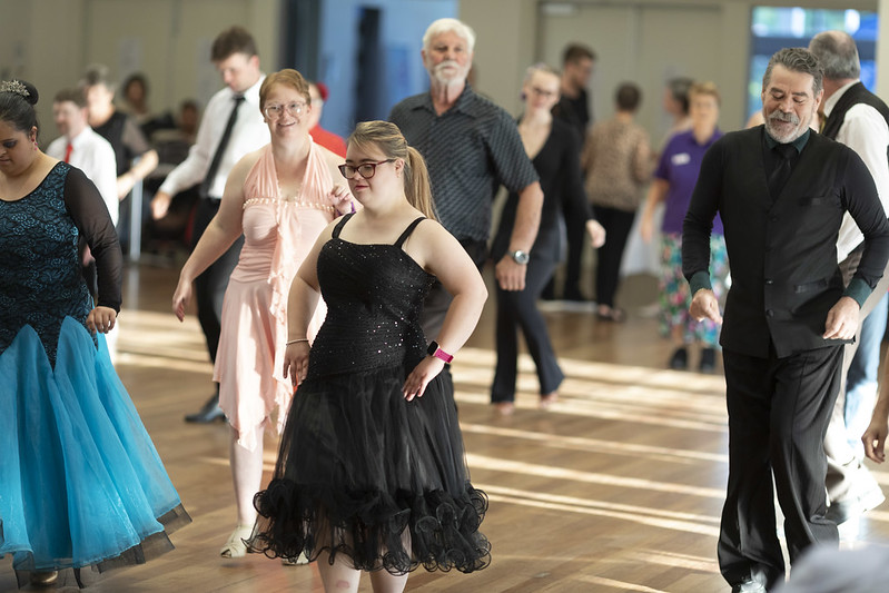 Group of people with disability and carers dancing in the ballroom