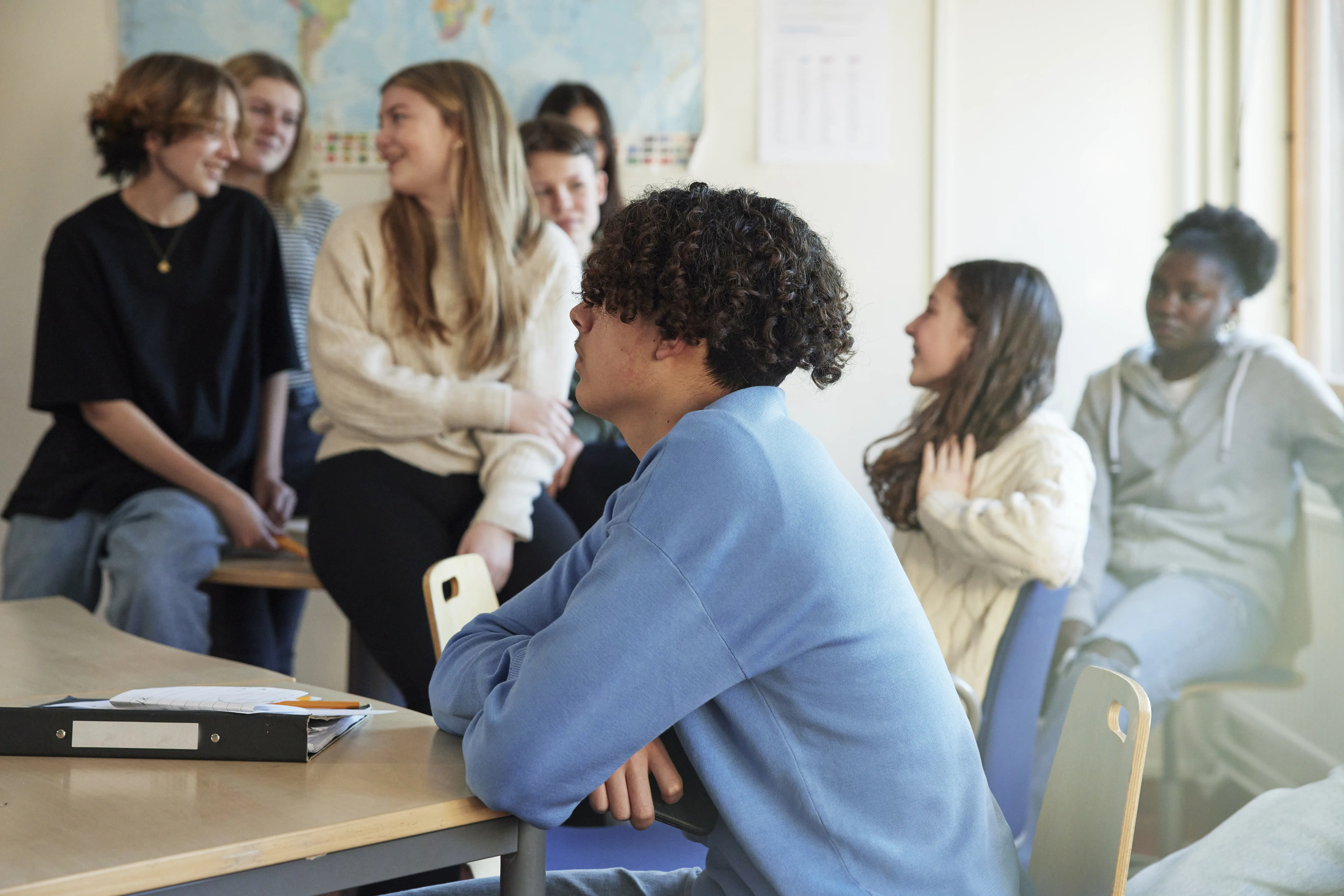 A mixed group of high-school students talking in classroom