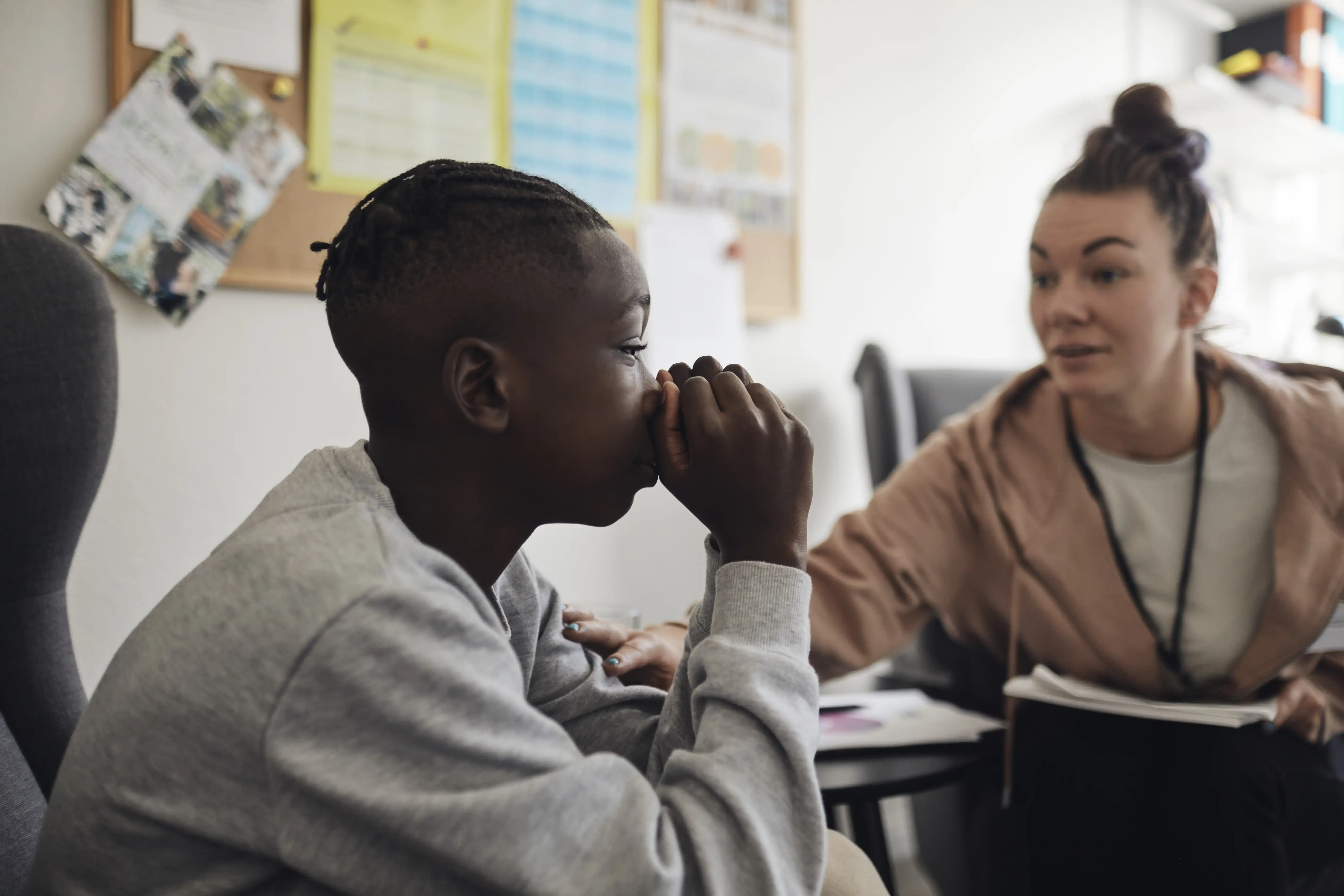 A young male listening to advice from a counsellor
