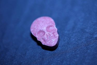 A close up of an ecstasy tablet shaped a skull 