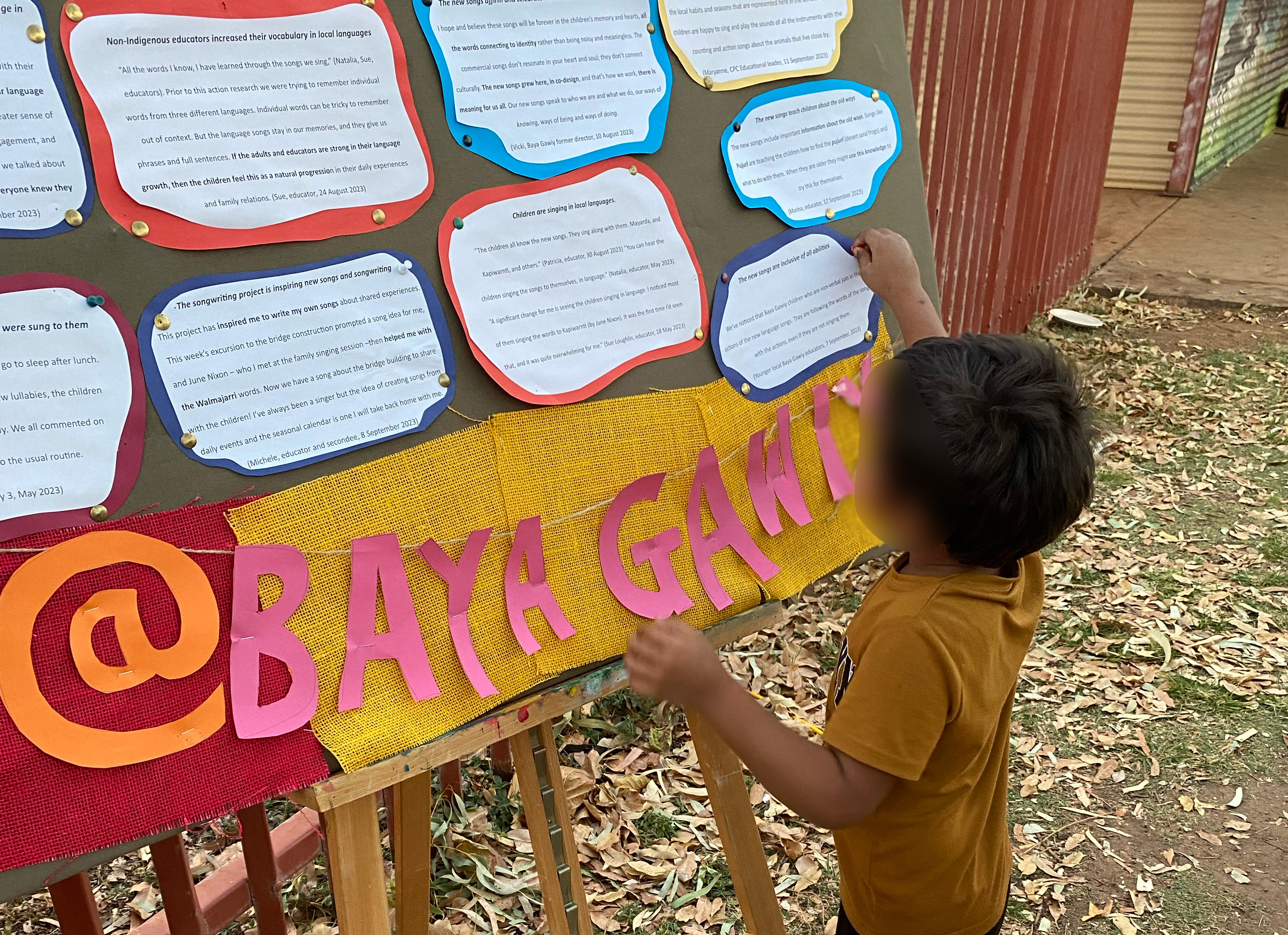 A young child looking at a handwritten story on a public noticeboard