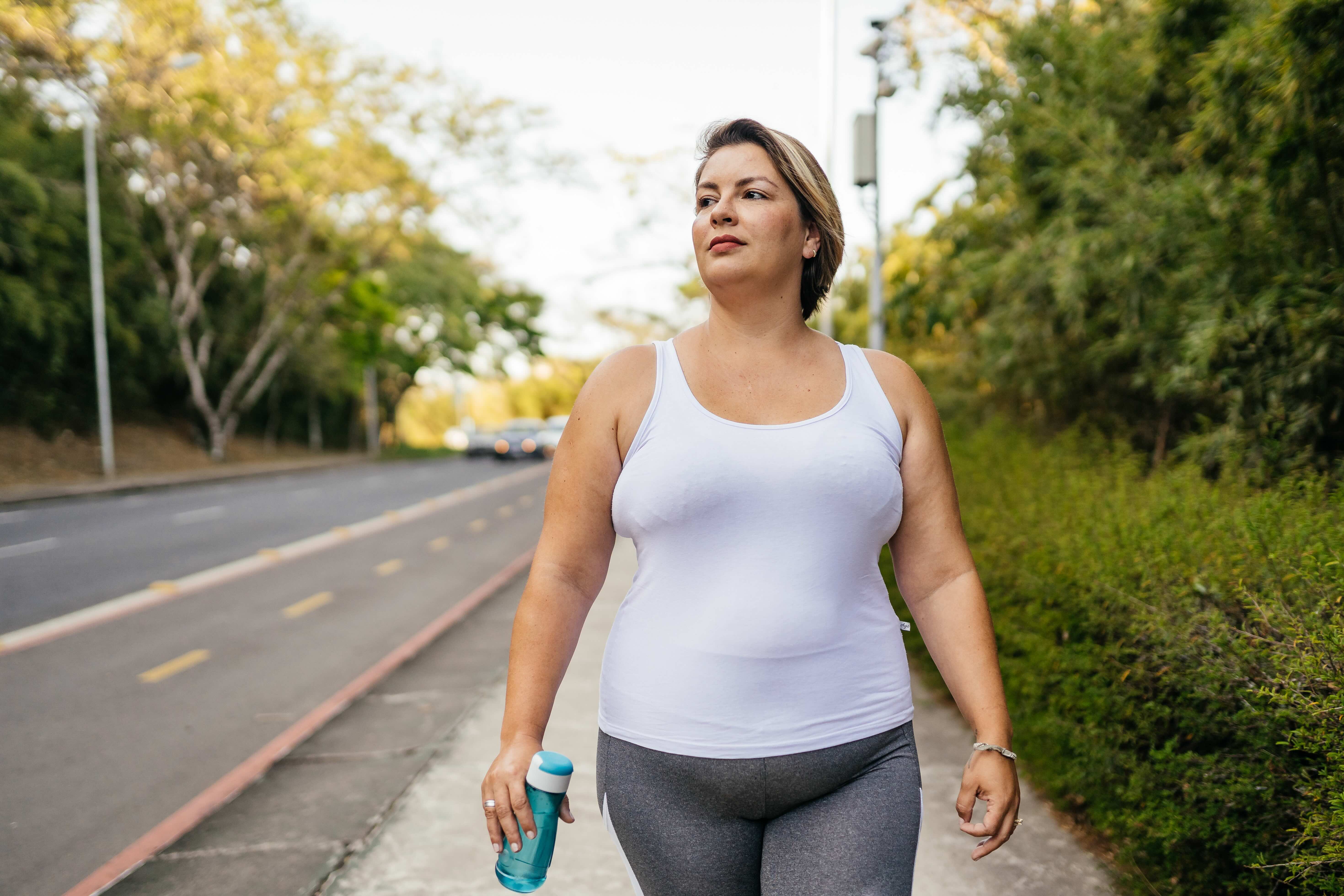 A woman talking a walk in a park for exercise