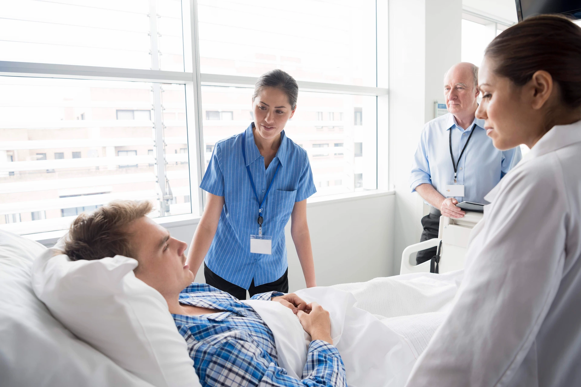 A man in a hospital bed talking to doctors