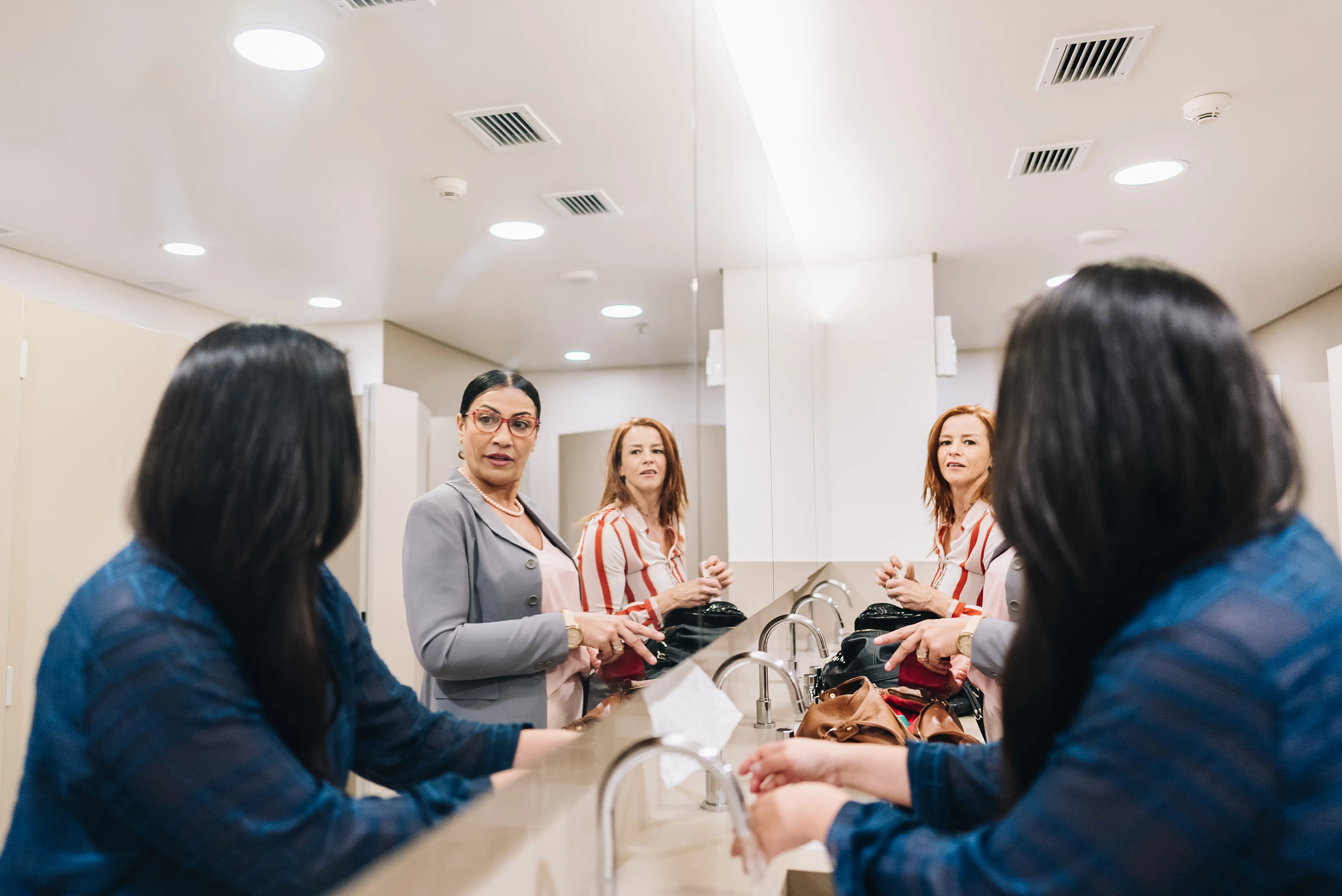 Women talking in an office bathroom