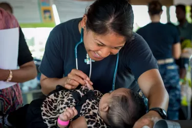 A health worker smiling at a baby 