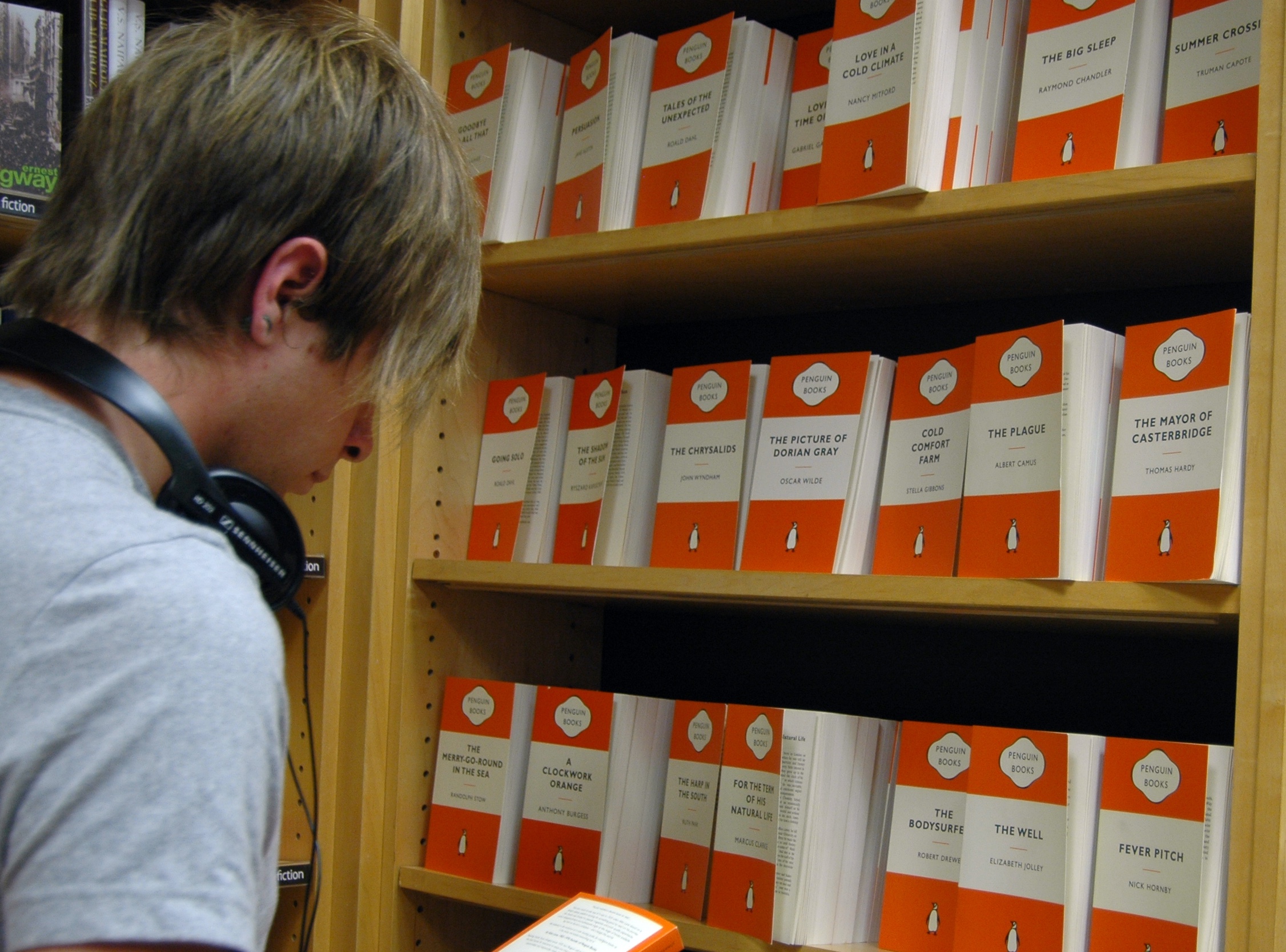 A teenager in front of a range of Penguin classic books