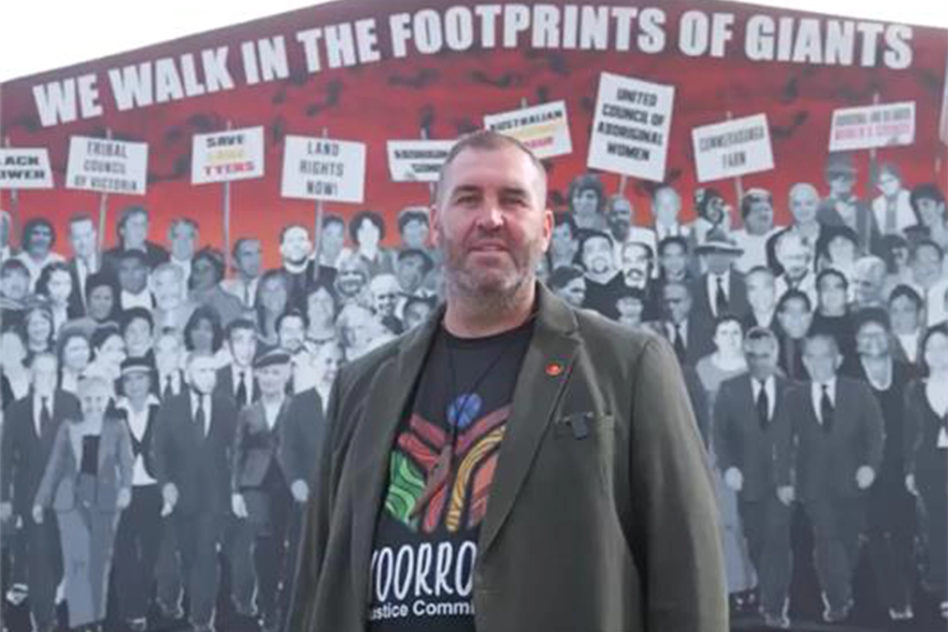 Travis Lovett in front of a mural