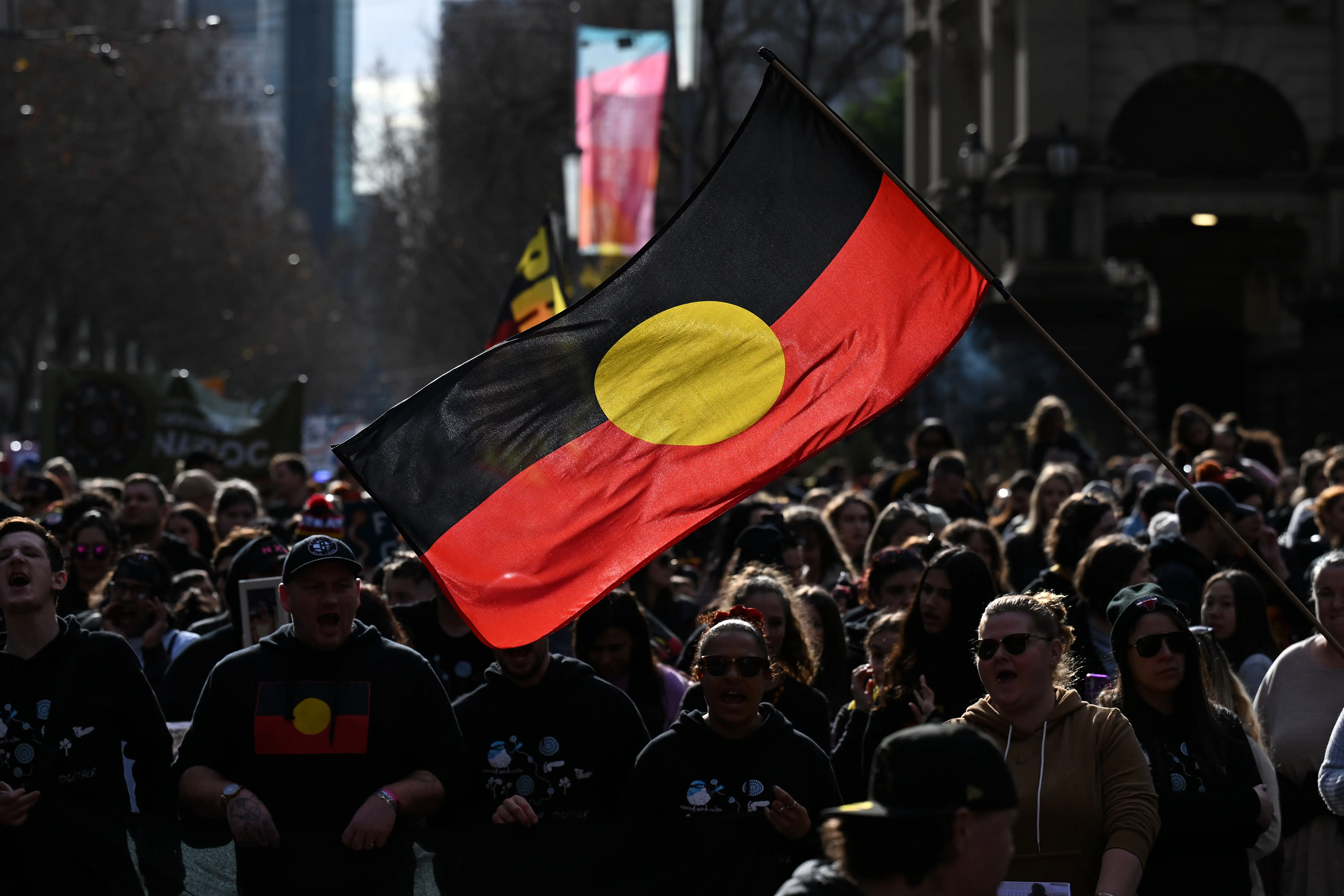 A person holds up the indigenous flag in Victoria.
