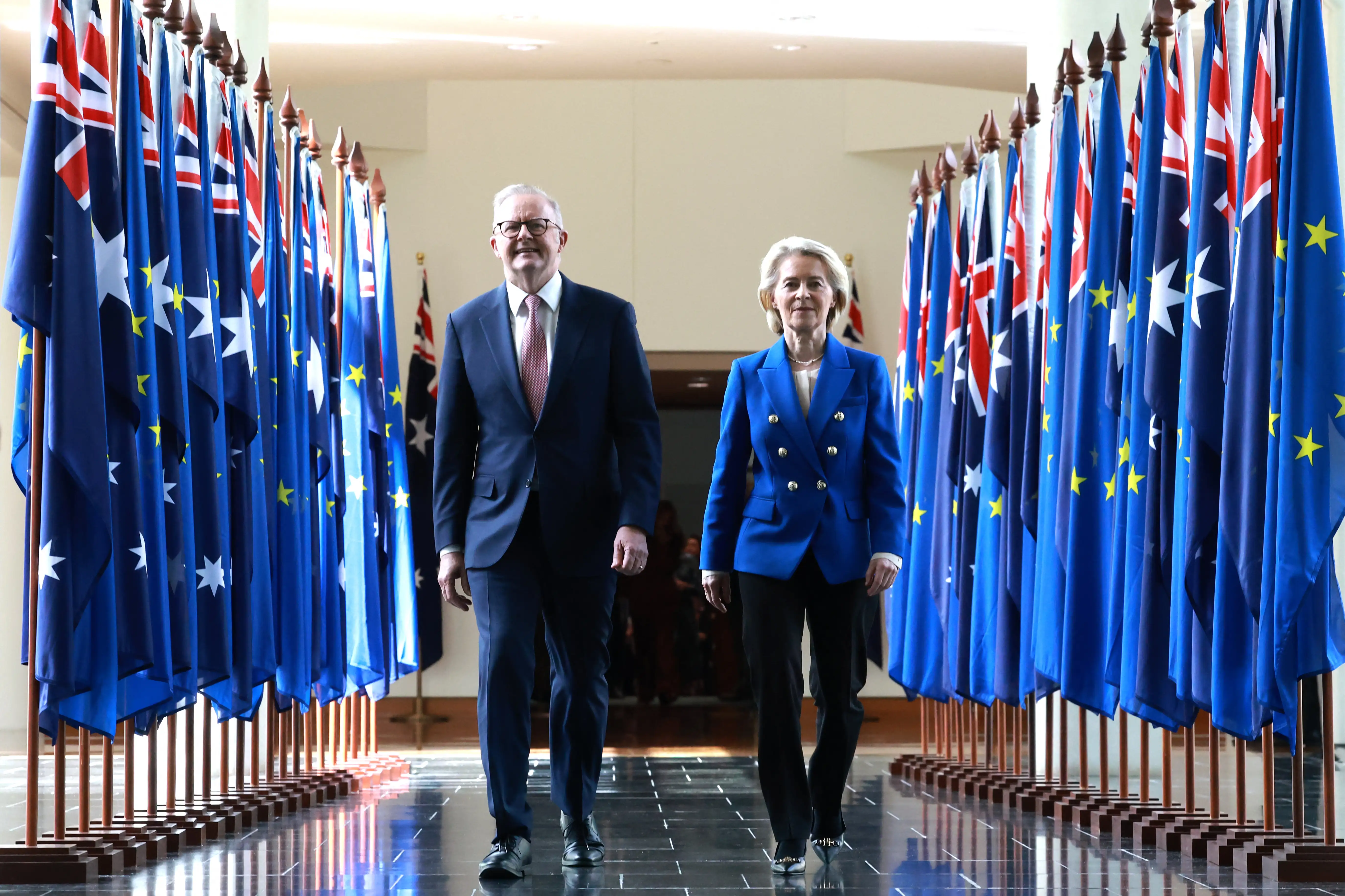 European Commission President Ursula von der Leyen (R) and Australian Prime Minister Anthony Albanese walk through the corridors of Parliament House