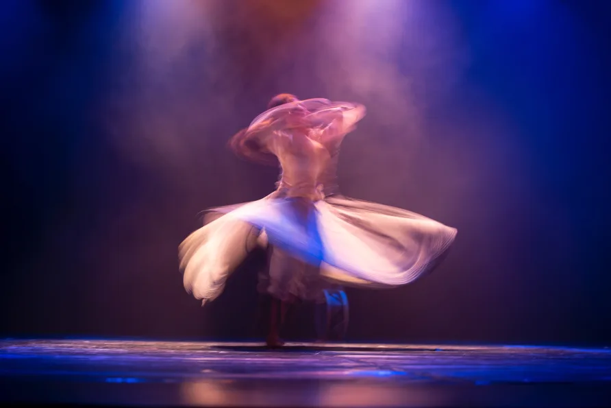 A dancer on a stage in a fast spin with skirt flying out