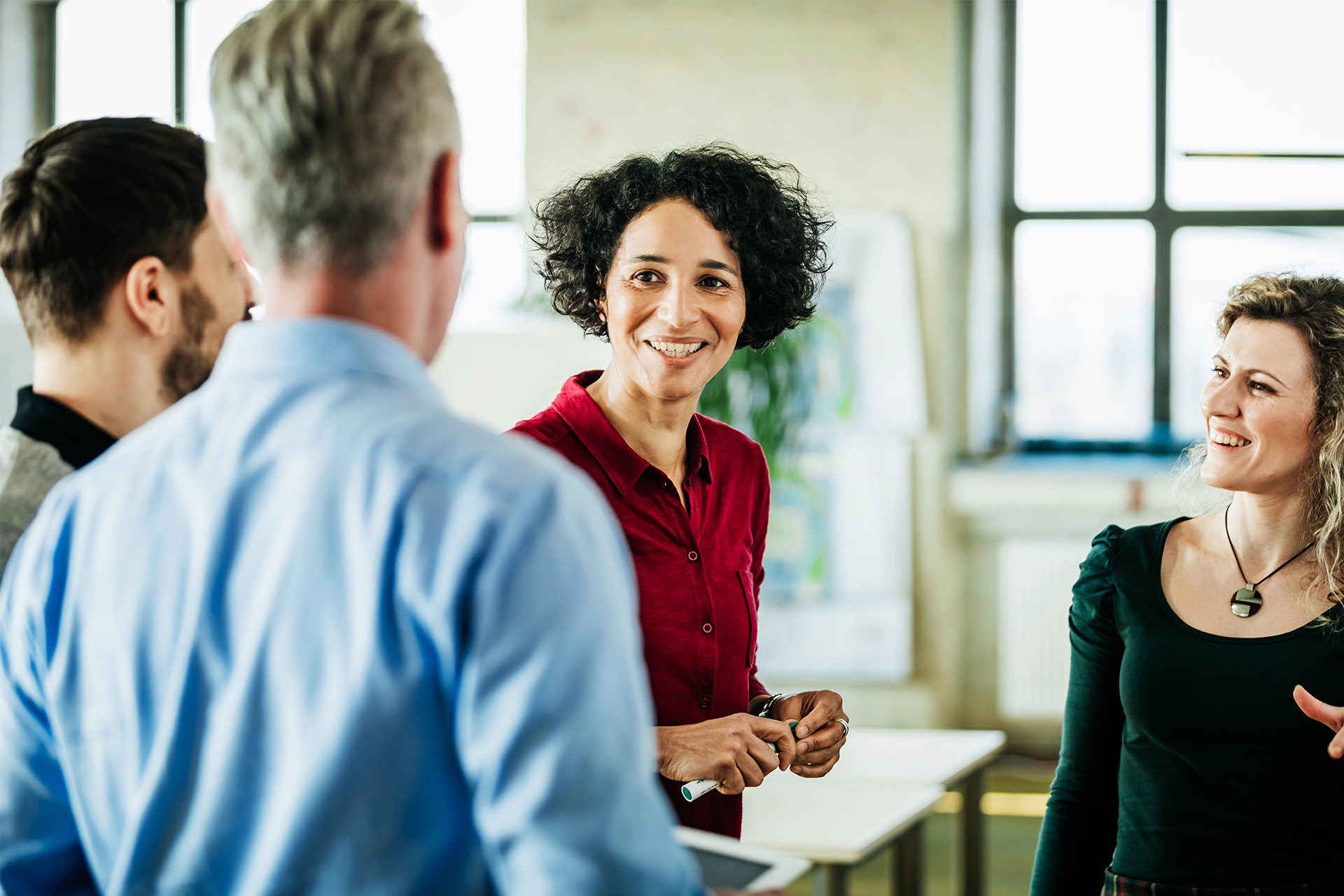 Group of people in an office talking and smiling