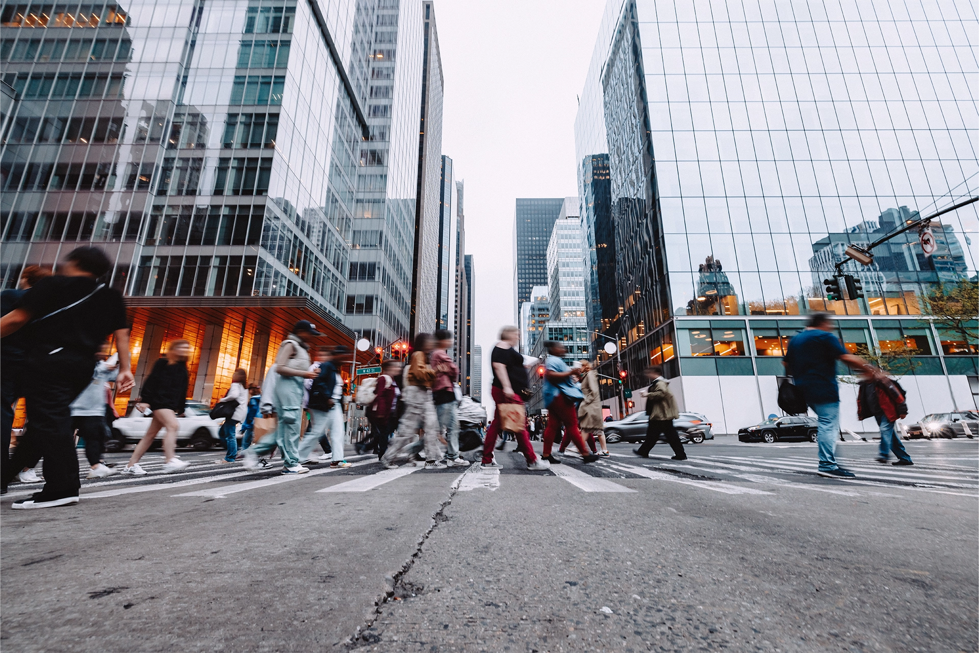 Crowd of people walking across a pedestrian crossing in New York