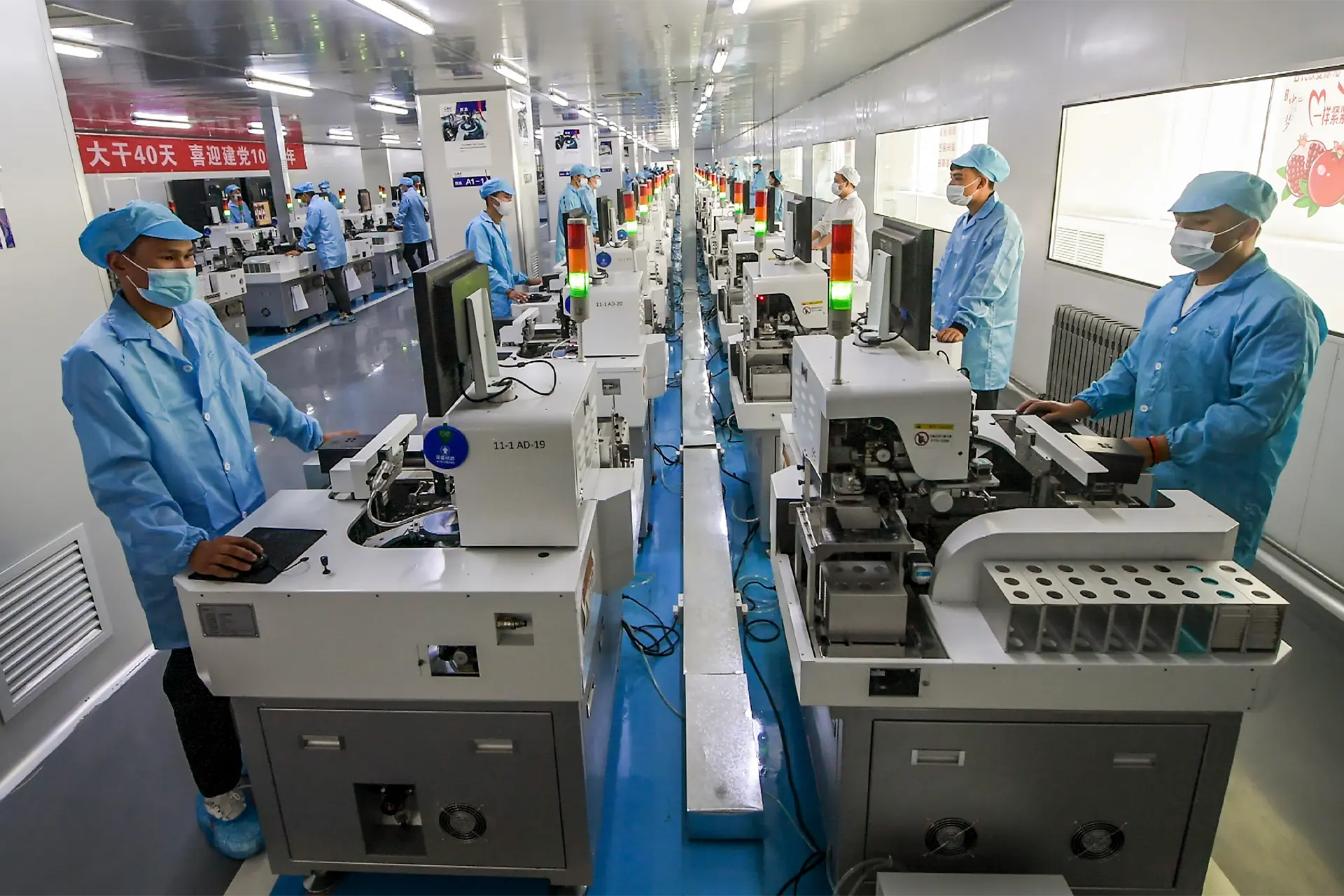 People standing at machines in high tech factory