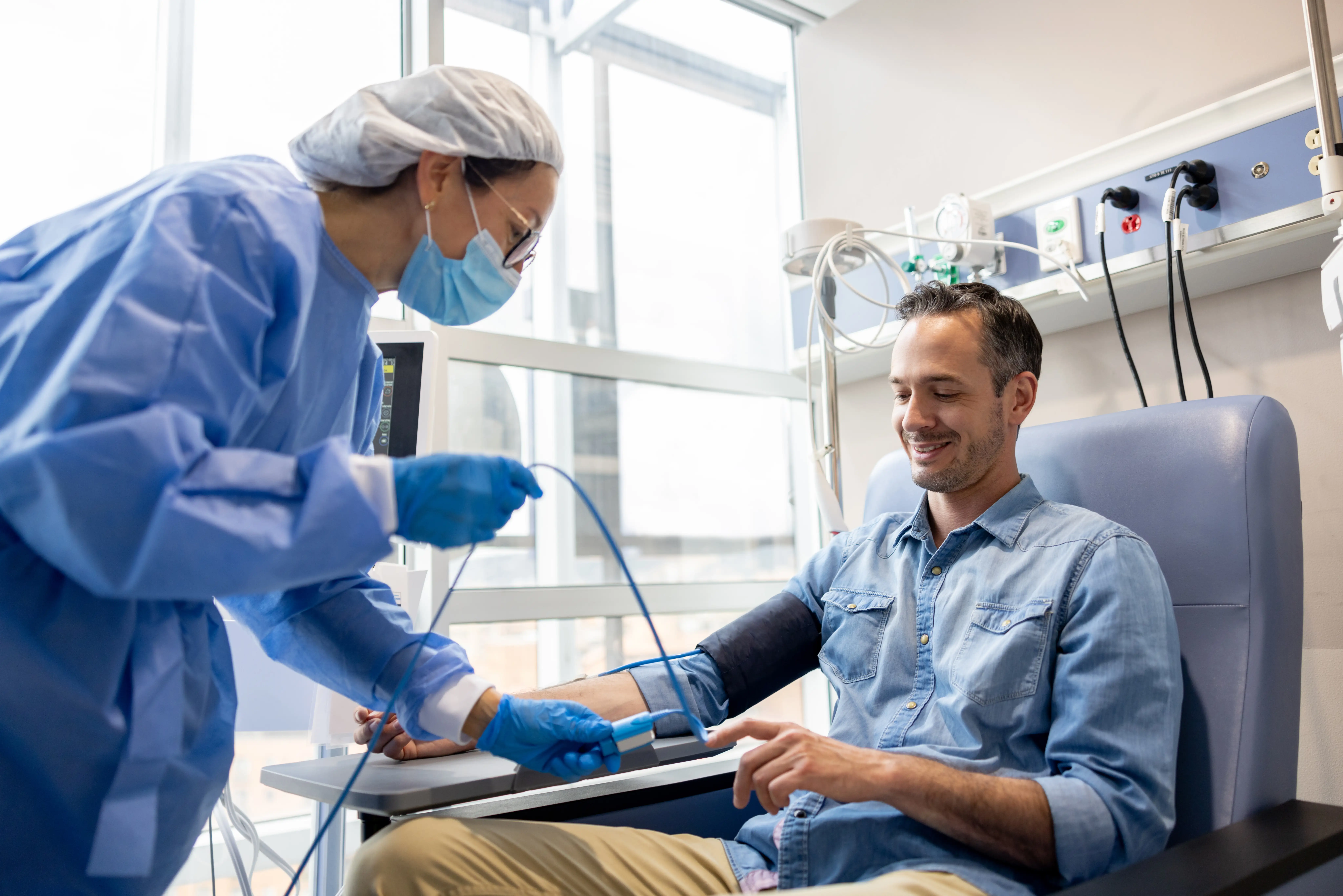 A young man having chemotherapy being attended by a nurse