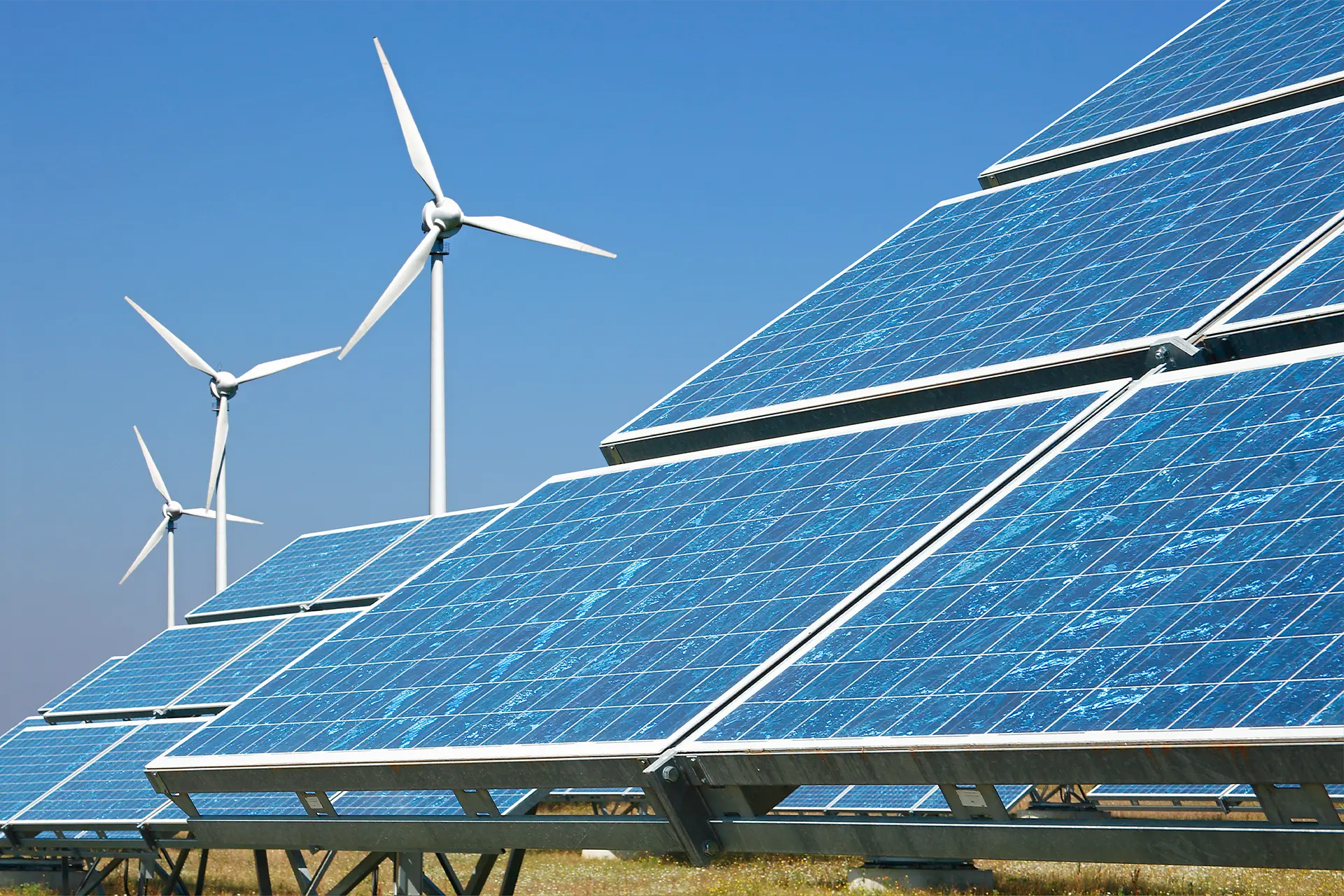 Solar panels and a wind farm in a field