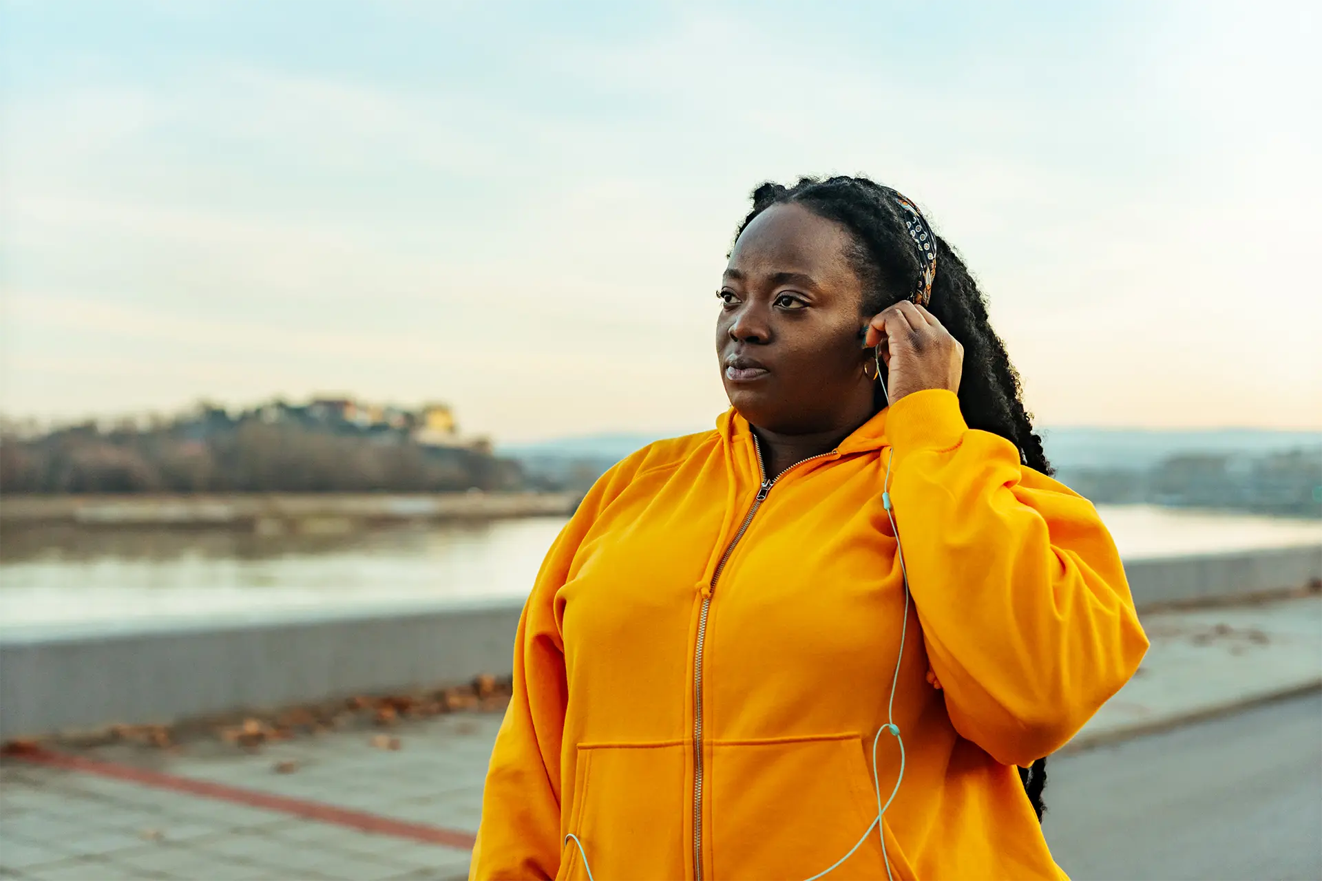 Woman outside preparing to exercise and putting headphones in