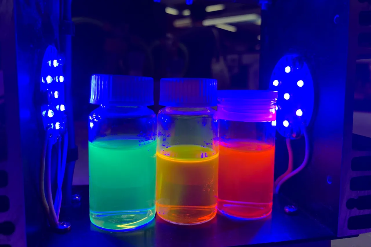 Liquids in flasks glowing under fluorescent lights